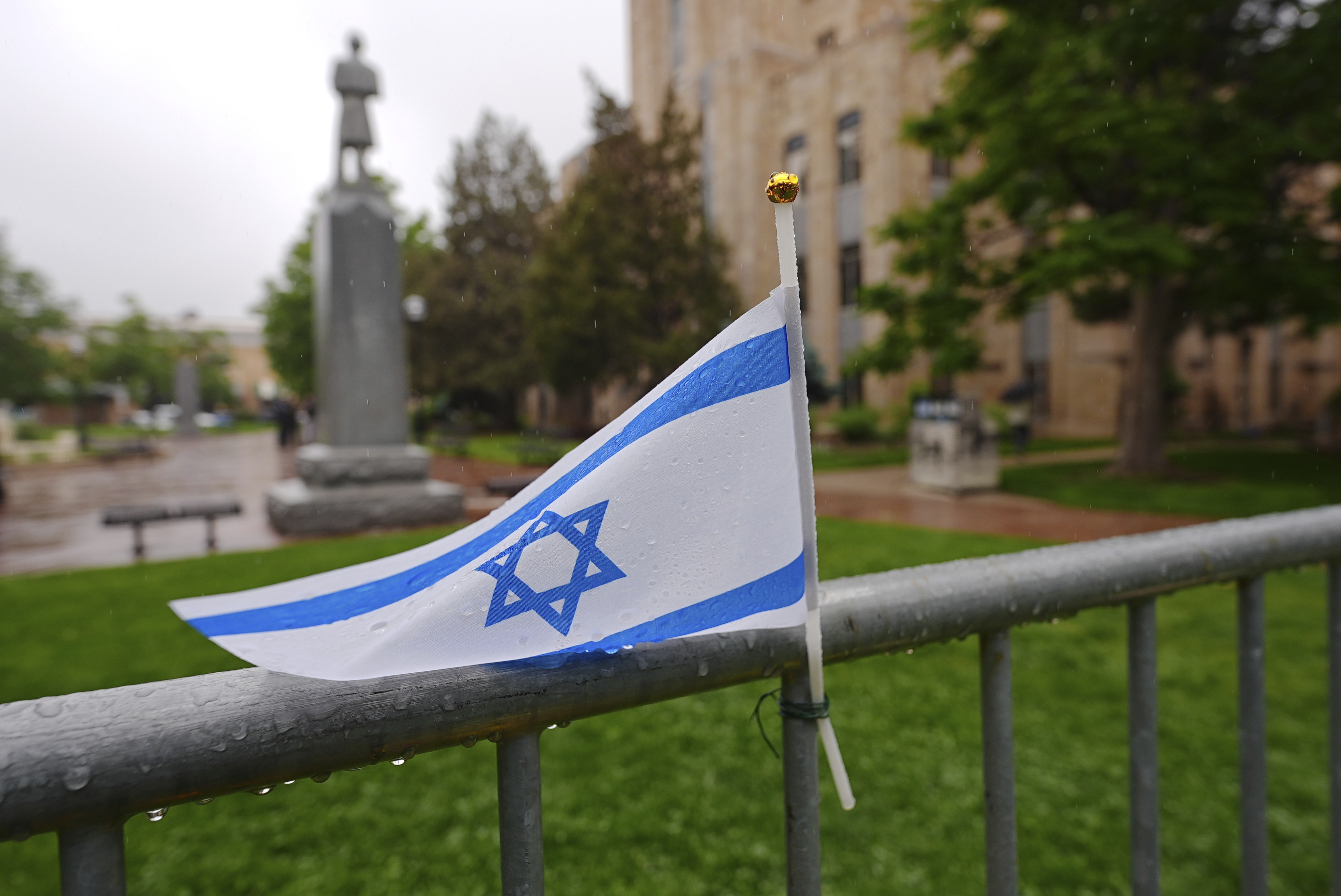 The flag of Israel tops a makeshift memorial for victims of an attack outside of the Boulder County, Colo., courthouse as a light rain falls Tuesday, June 3, 2025, in Boulder, Colo. (AP Photo/David Zalubowski)