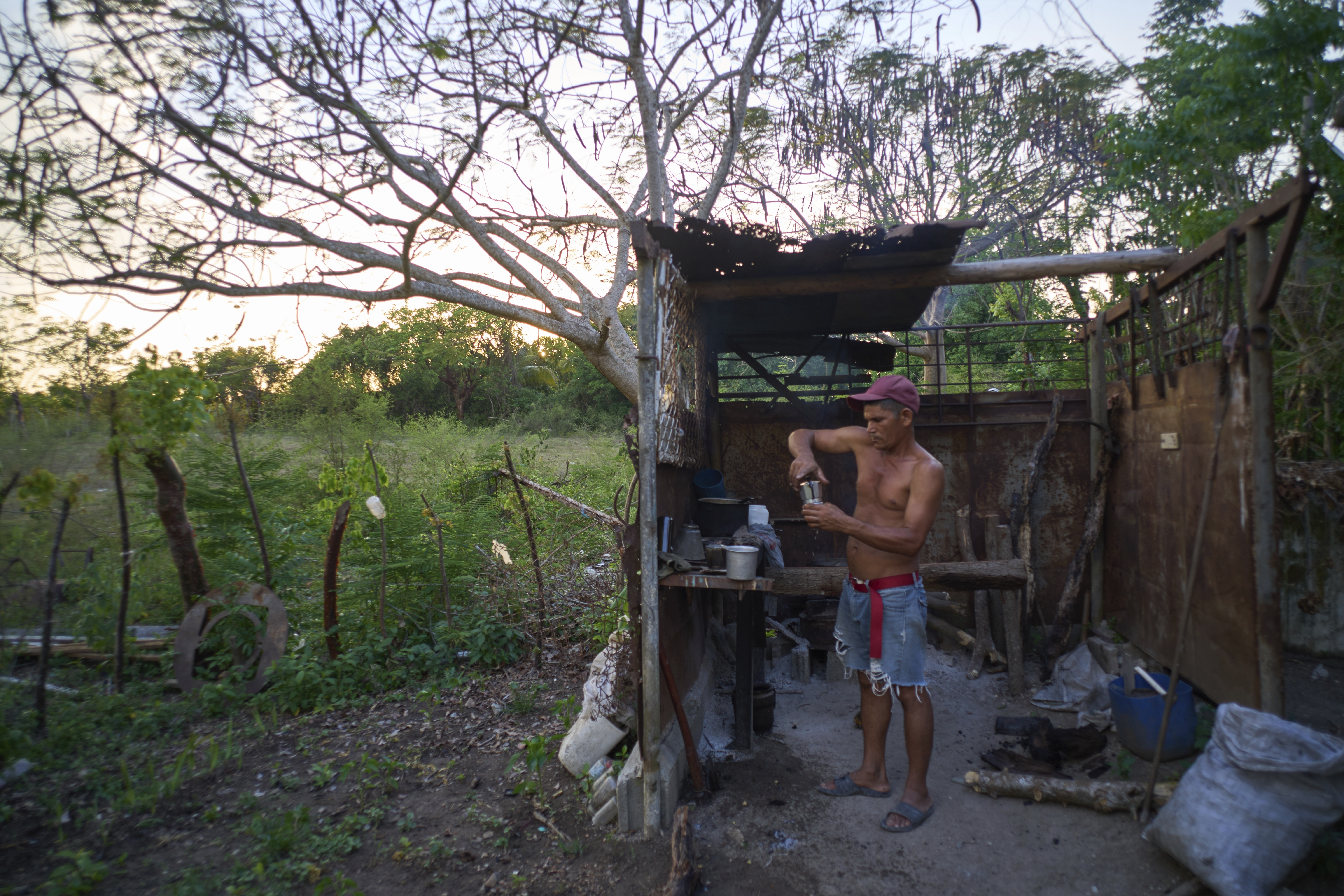 Edinector Vazquez prepares coffee on a charcoal stove behind his home during a blackout in Minas, Havana province, Cuba, Monday, May 26, 2025. (AP Photo/Ramon Espinosa)