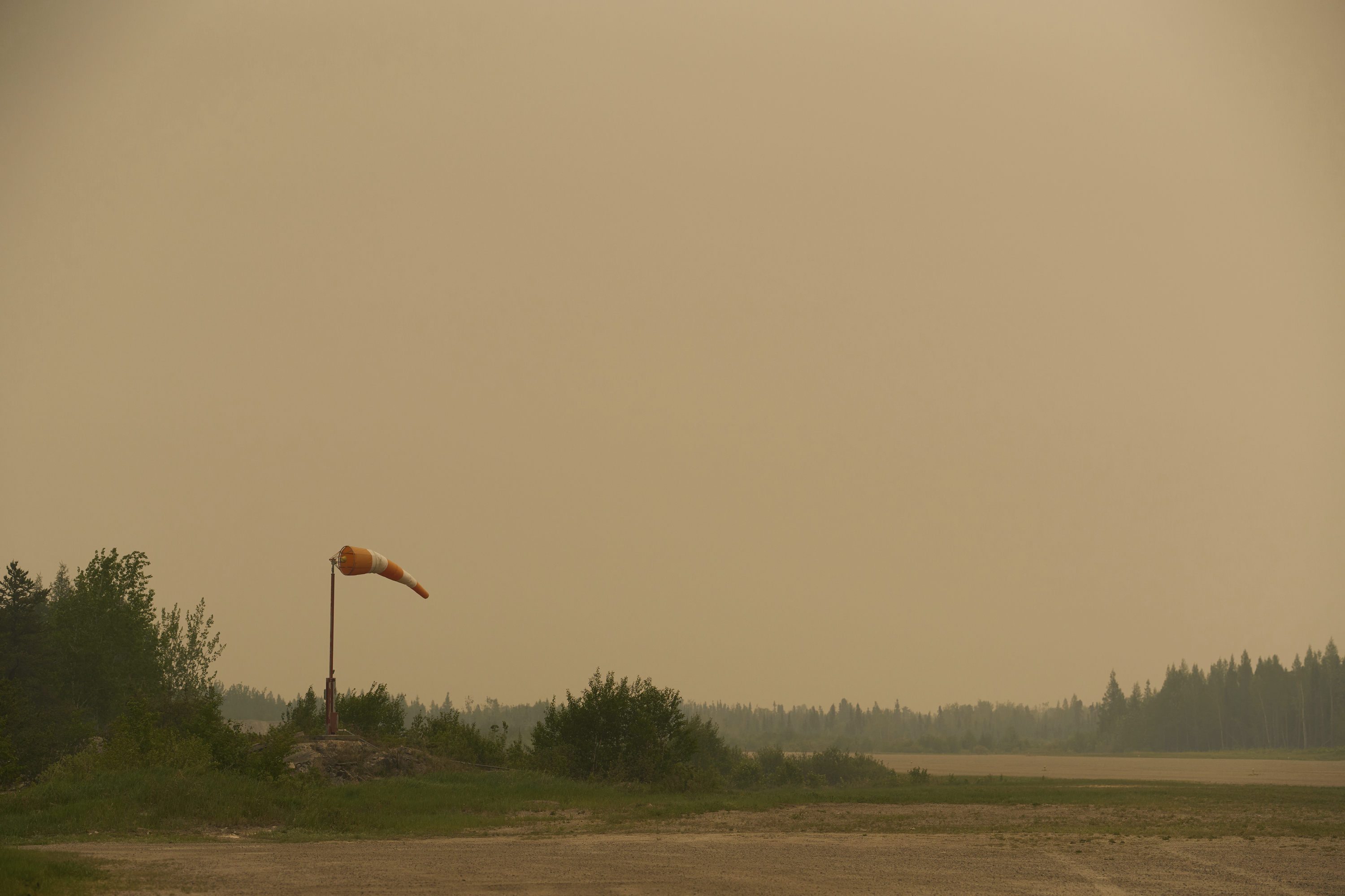 Smoke filled skies from out of control wildfires in Norway House, Manitoba Tuesday, June 3, 2025, at the Norway House Airport as crews continue to fight wildfires in northern Manitoba. (David Lipnowski/The Canadian Press via AP)