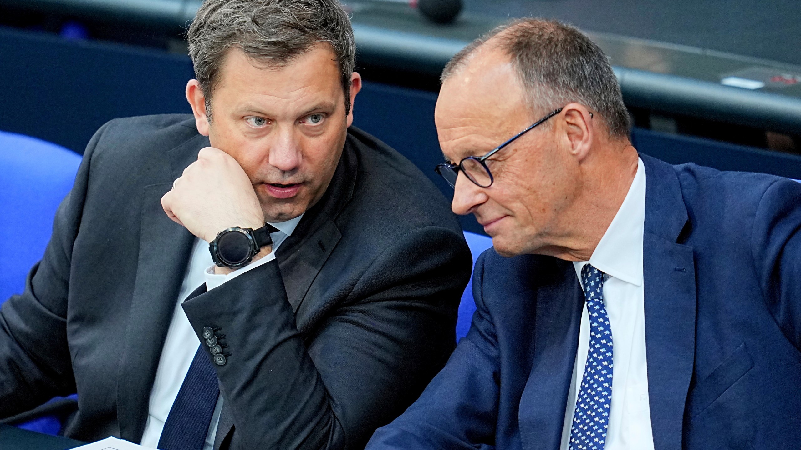 German Chancellor Friedrich Merz, right, and German Finance Minister Lars Klingbeil, left, talk during a meeting of the German parliament, Bundestag, at the Reichstag building in Berlin, Germany, Wednesday, May 14, 2025. (Michael Kappeler/dpa via AP)