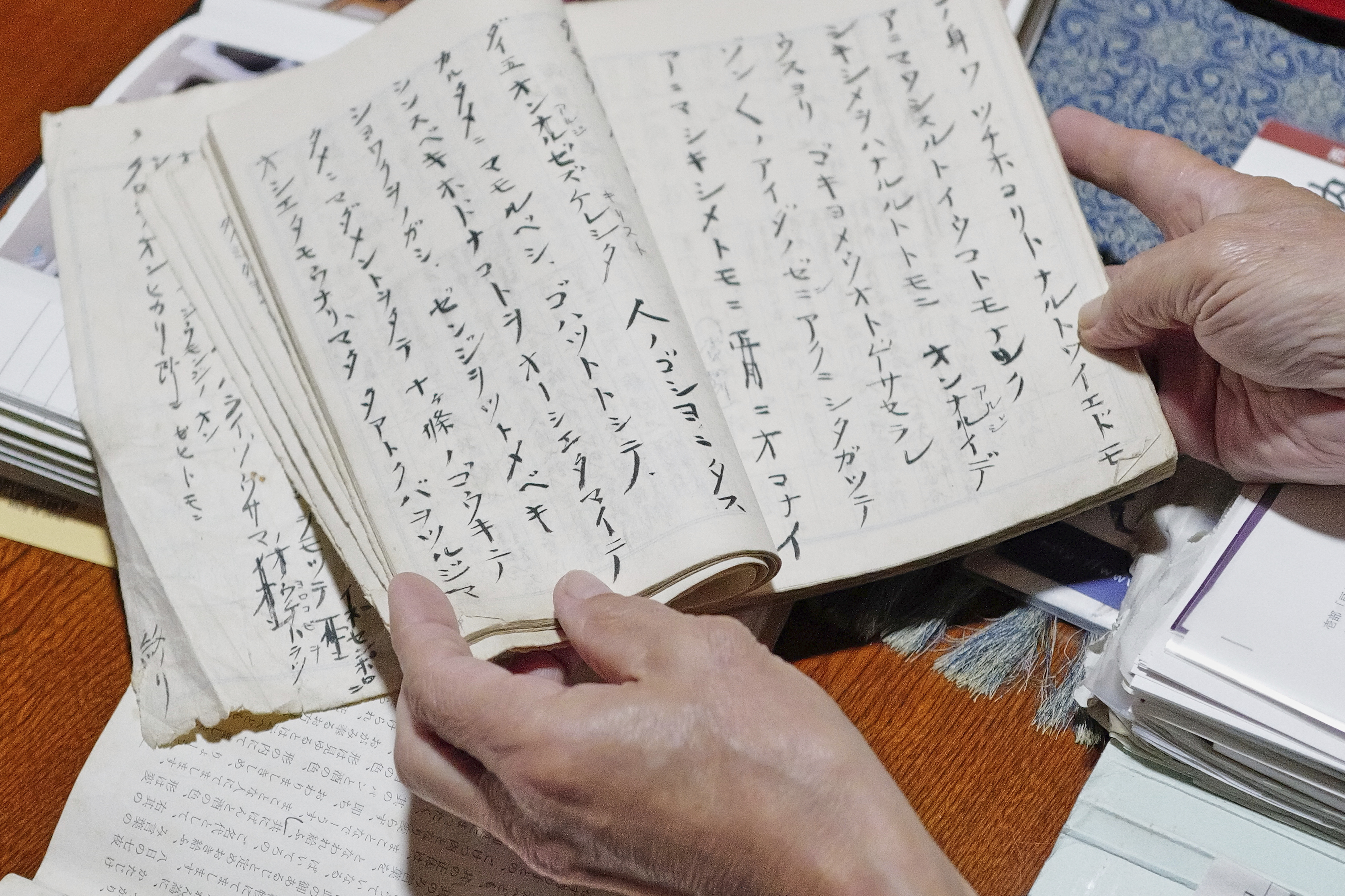 Masatsugu Tanimoto, a farmer and a community leader who is one of only hundreds of so-called "hidden" Christians on the island of Ikitsuki, shows a notebook of handwritten "orasho" prayers passed down orally for generations at his home in Ikitsuki Island in Hirado, southern Japan, Sunday, April 27, 2025. (AP Photo/Eugene Hoshiko)