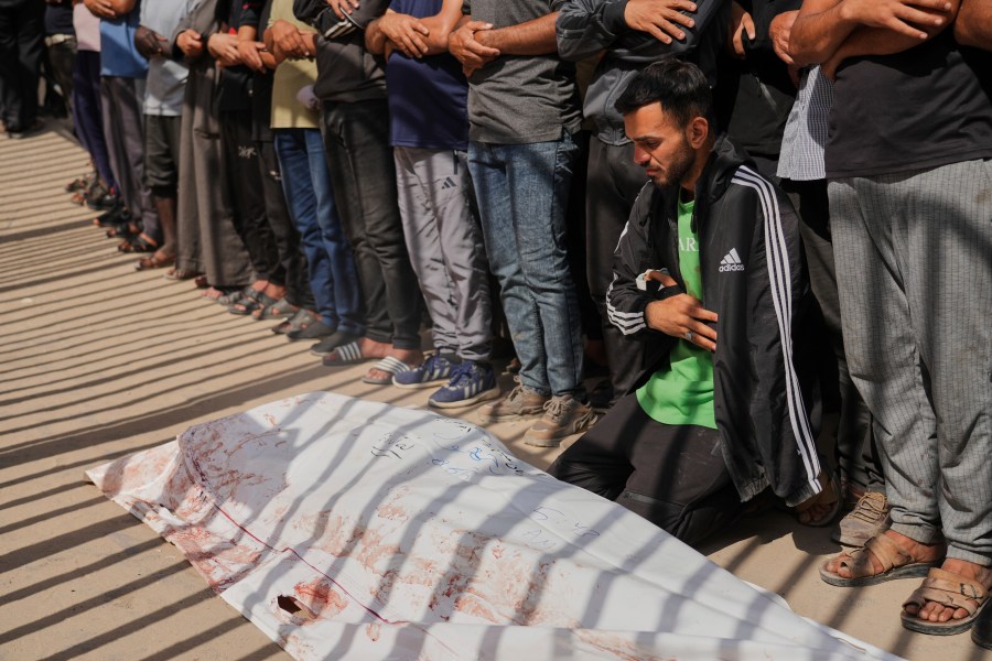 Mourners pray beside the body of Adnan Abu Harb who was killed while heading to a Gaza aid hub, during his funeral at the Nasser Hospital in Khan Younis, southern Gaza Strip, Tuesday, June 3, 2025. (AP Photo/Abdel Kareem Hana)