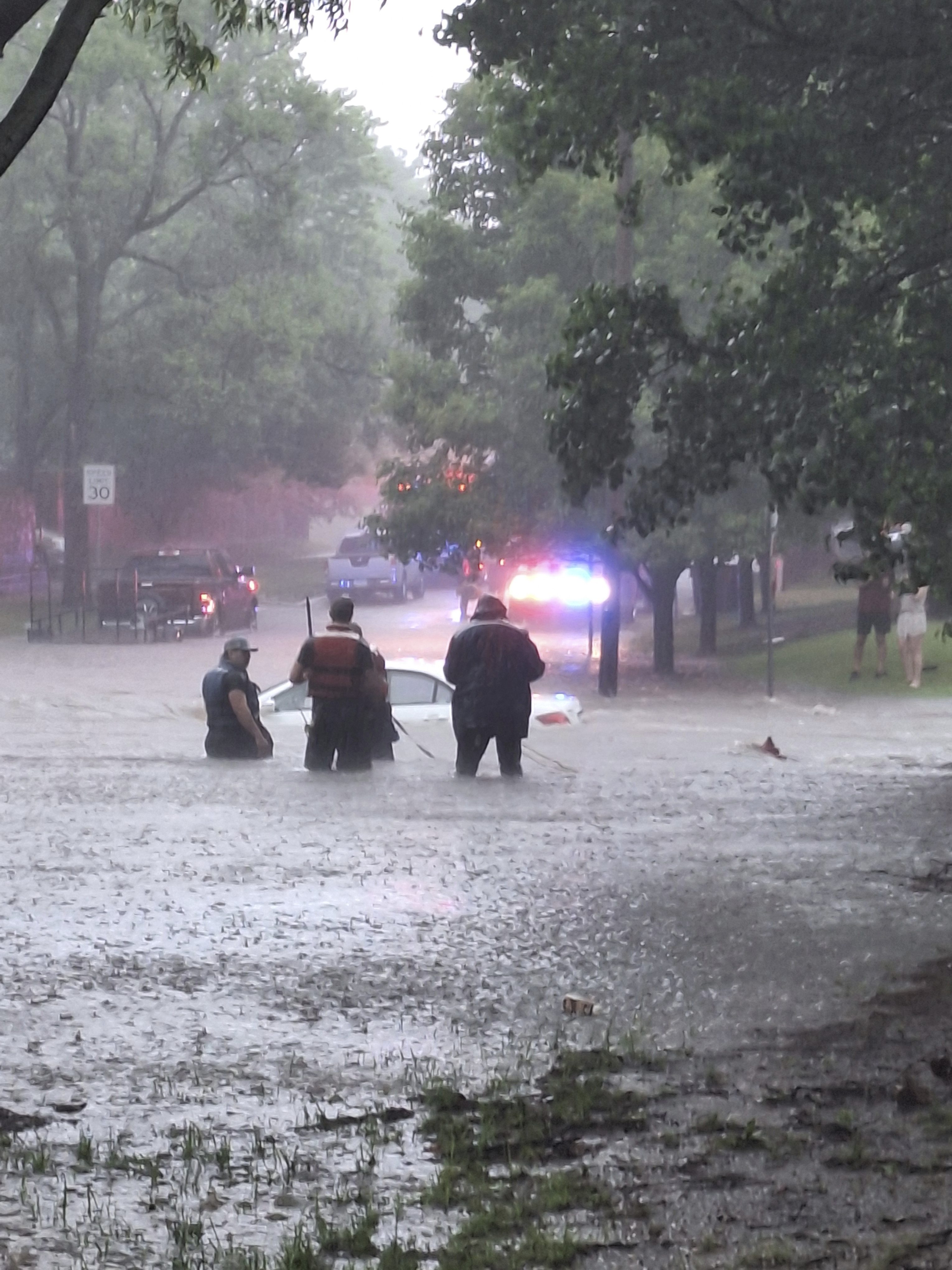 This photo provided by Colin Fee, a vehicle is surrounded by flood waters as heavy rains caused flash flooding in the Wichita area of south-central Kansas forcing firefighters to rescue dozens of people, including stranded motorists on Tuesday, June 3, 2025. (Colin Fee via AP)
