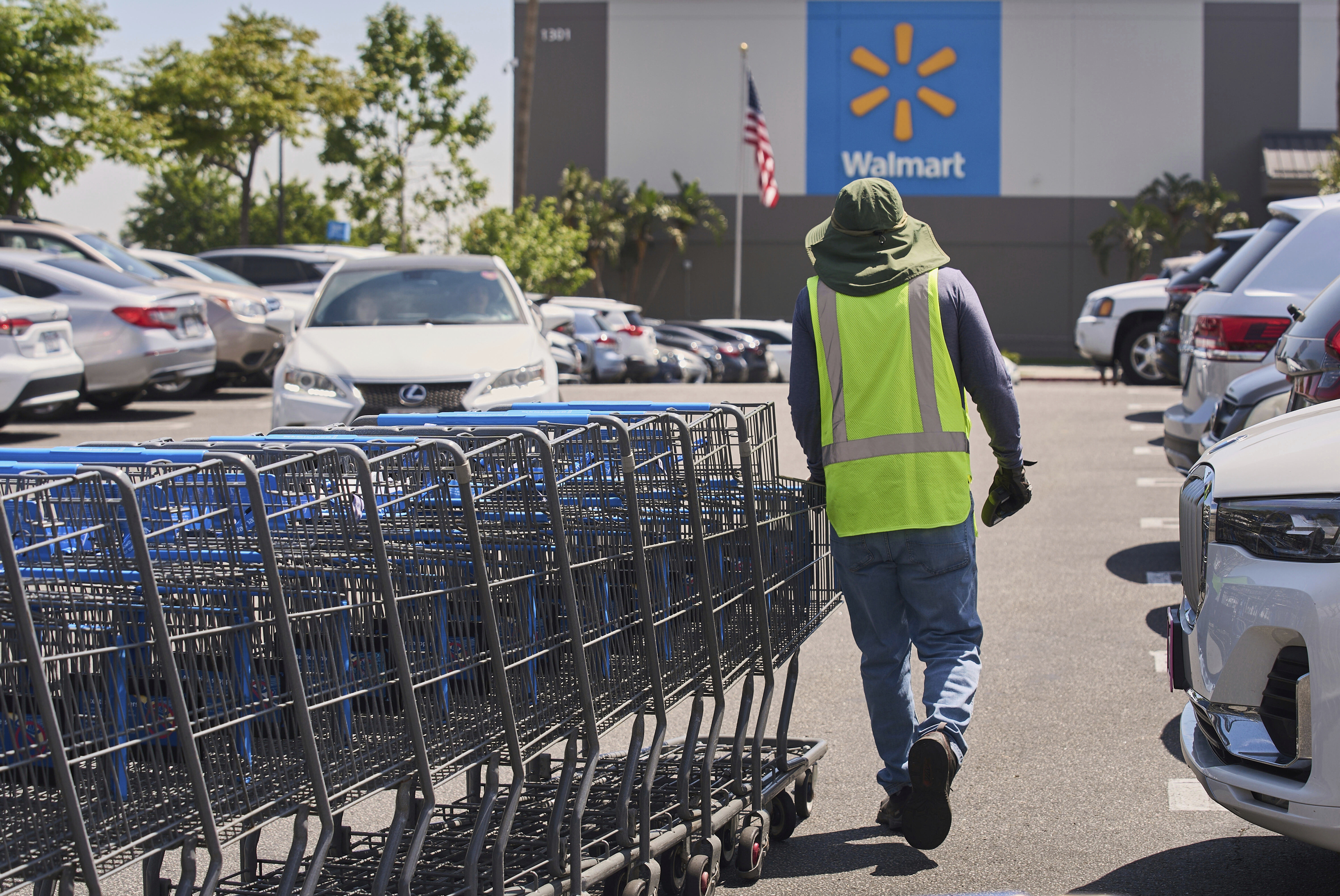 FILE - Empty shopping carts are collected from the parking lot at Walmart store in Burbank, Calif., on Thursday, April 10, 2025. (AP Photo/Damian Dovarganes, File)