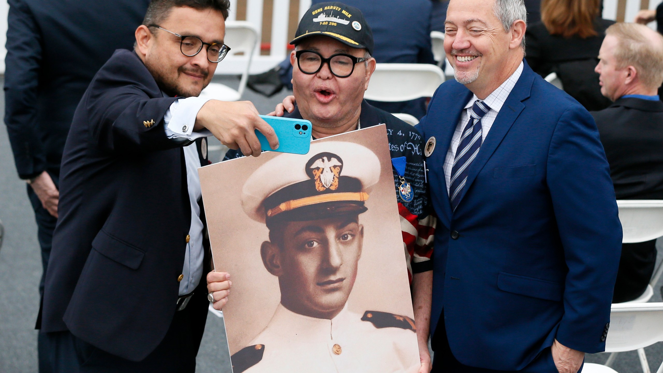 FILE - David Campos, left, vice chair of the California Democratic Party, takes a selfie with Nicole Murray-Ramirez, center, an LGBT activist, holding a photo of Harvey Milk, and Bevan Dufty, right, director of the San Francisco Bay area rapid transit district, prior to the launching of the USNS Harvey Milk, a fleet replenishment oiler ship named after the first openly gay elected official, Saturday, Nov. 6, 2021 in San Diego. (AP Photo/Alex Gallardo, File)