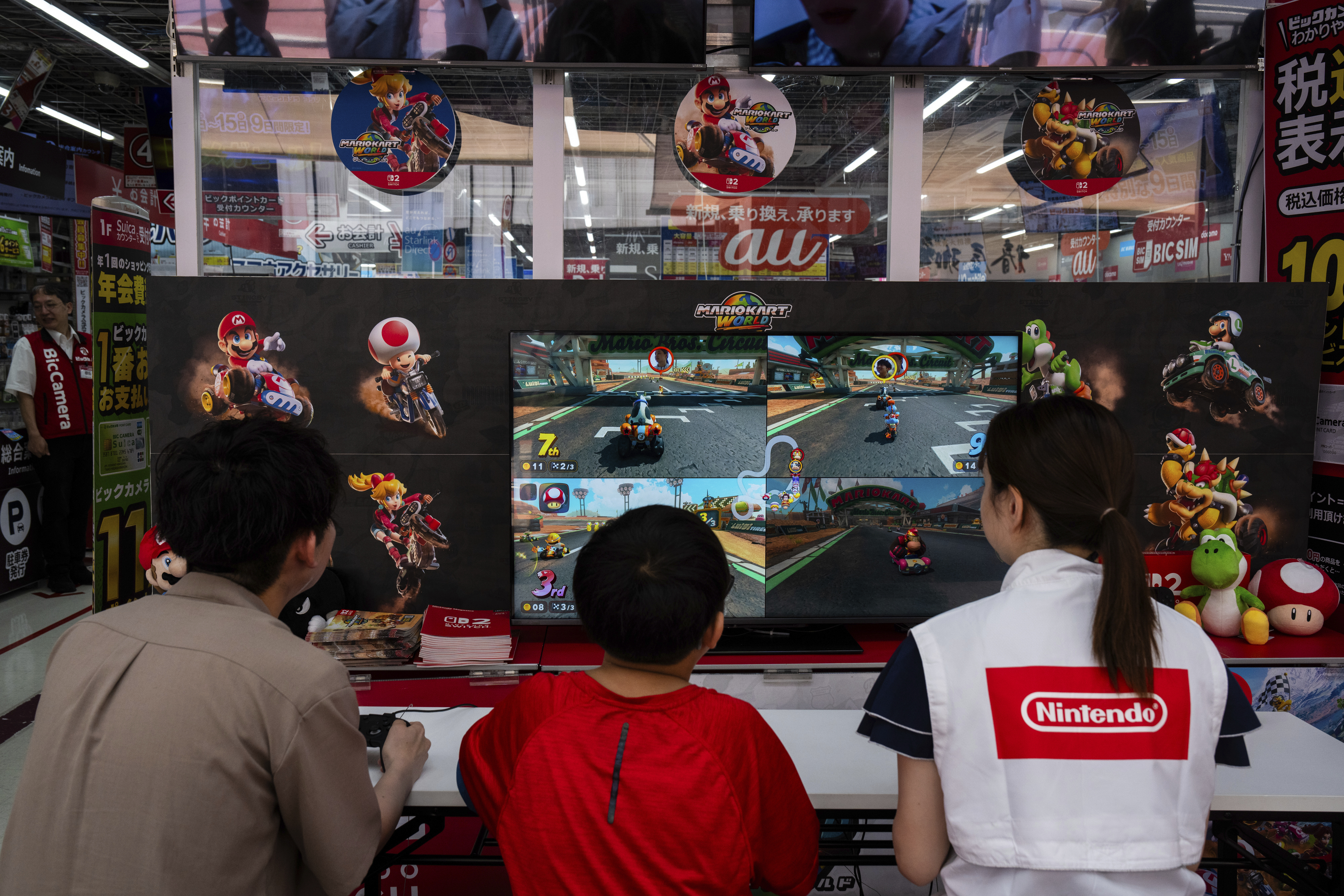 Staff and members of the public try the Nintendo Switch 2 during a launch event at an electronics retailer in Tokyo, Thursday, June 5, 2025. (AP Photo/Louise Delmotte)