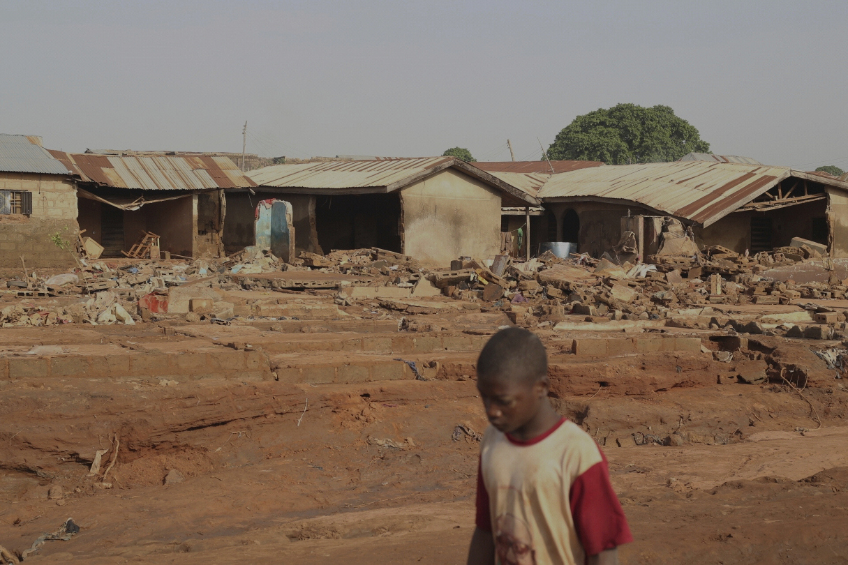 FILE - A boy walks past a flooded area after heavy rainfall in the market town of Mokwa, north-central Nigeria, Saturday May 31, 2025. (AP Photo/Usman Salihu Mokwa), File)