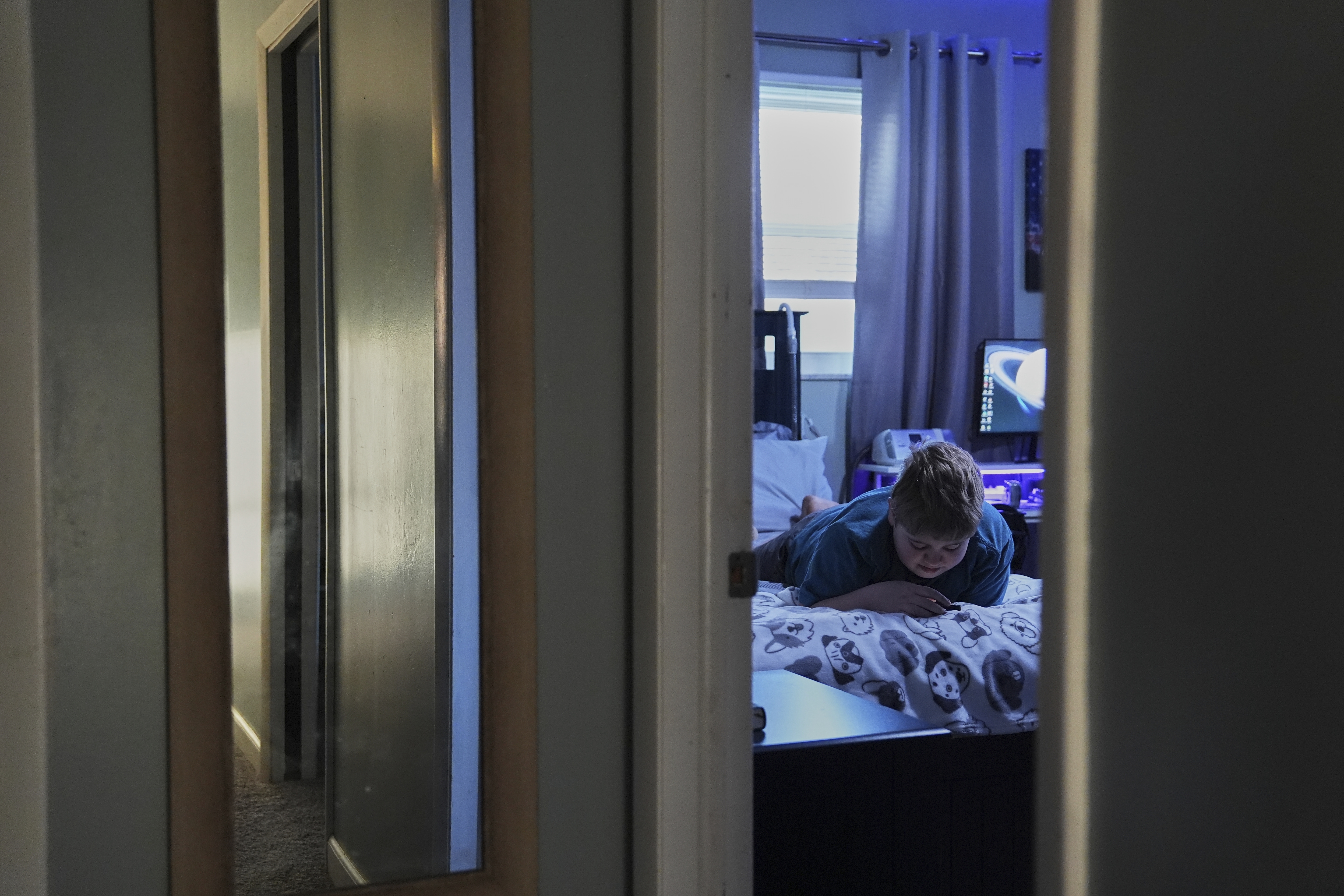 Julian Blazier relaxes in his bedroom Tuesday, April 8, 2025, in Bloomfield, Ind. (AP Photo/Joshua A. Bickel)