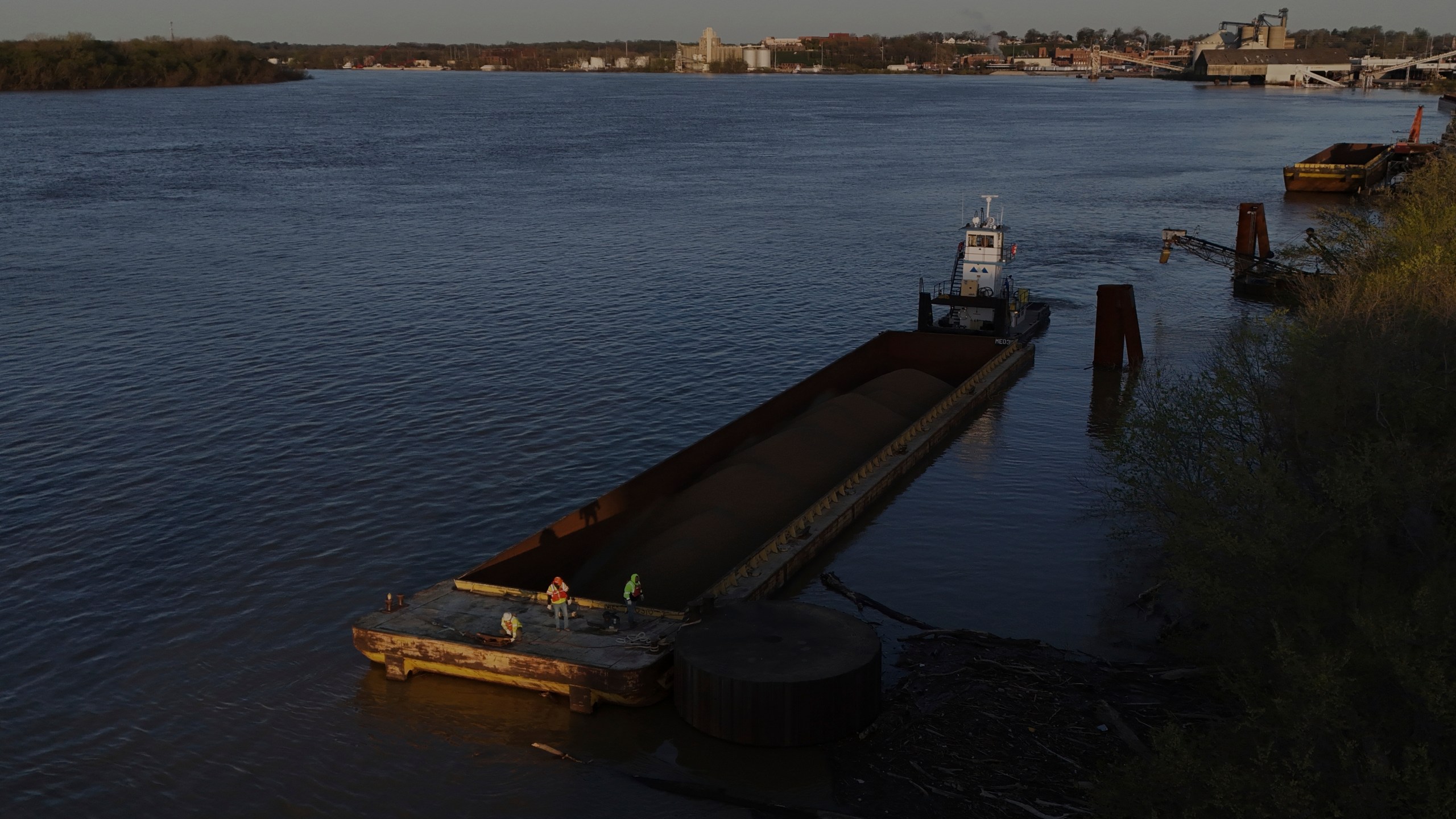 A crew works on a coal barge Tuesday, April 8, 2025, in Evansville, Ind. (AP Photo/Joshua A. Bickel)