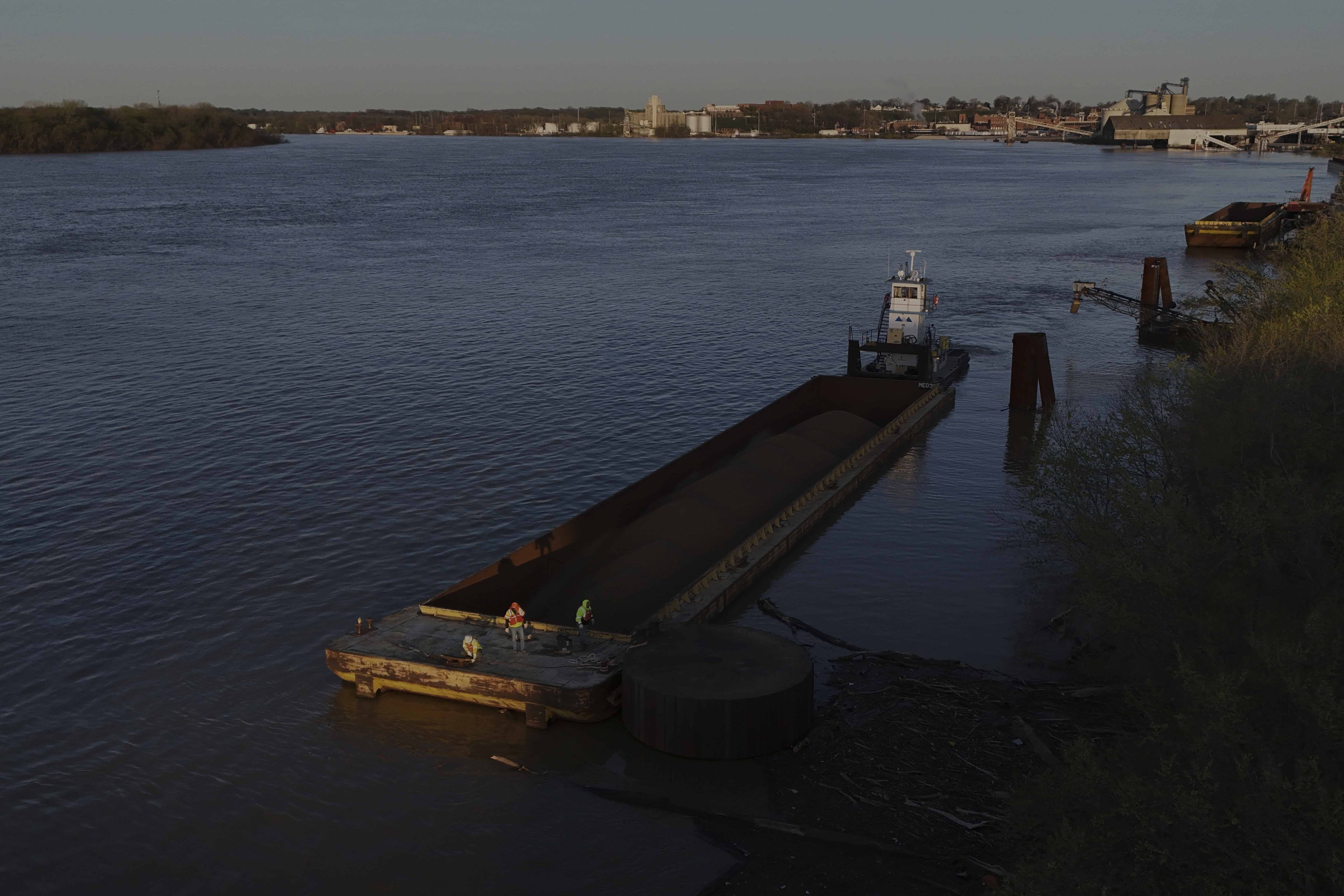 A crew works on a coal barge Tuesday, April 8, 2025, in Evansville, Ind. (AP Photo/Joshua A. Bickel)