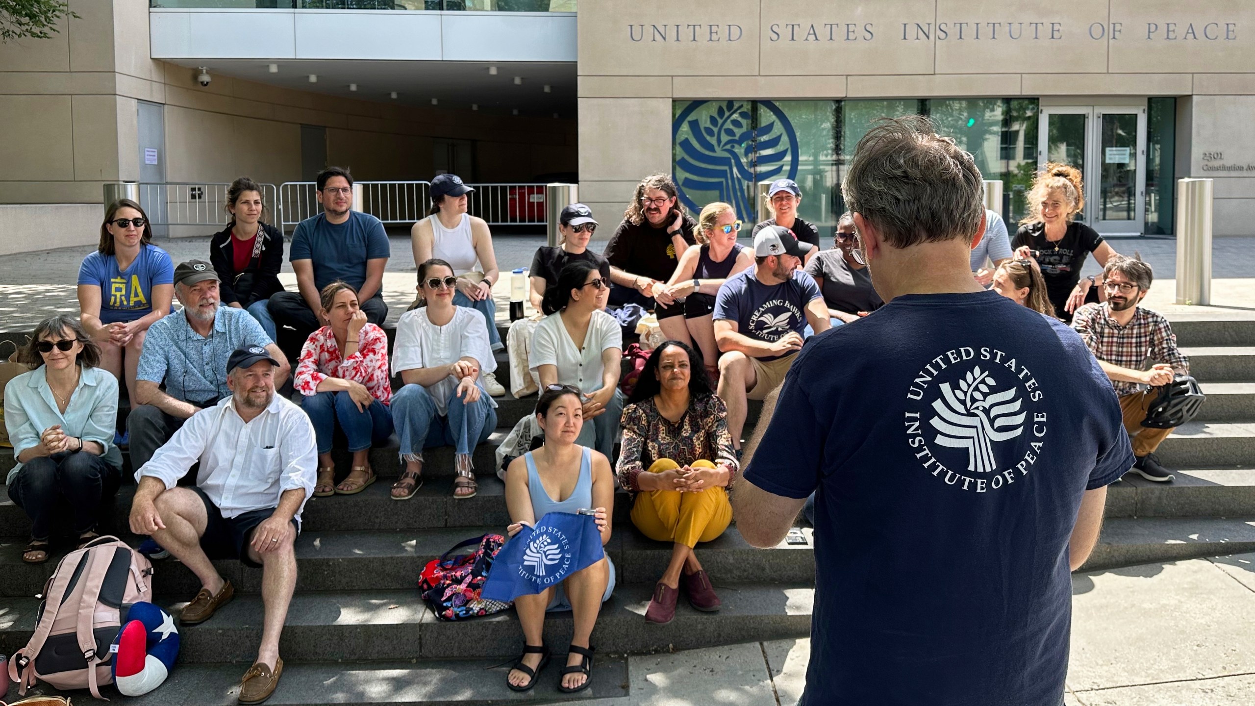 U.S. Institute of Peace employees hold an impromptu celebration on the steps of the U.S. Institute of Peace, Monday, May 19, 2025, in Washington, after federal district Judge Beryl A. Howell blocked the Trump administration from moving forward with dismantling the organization. (AP Photo/Gary Fields)