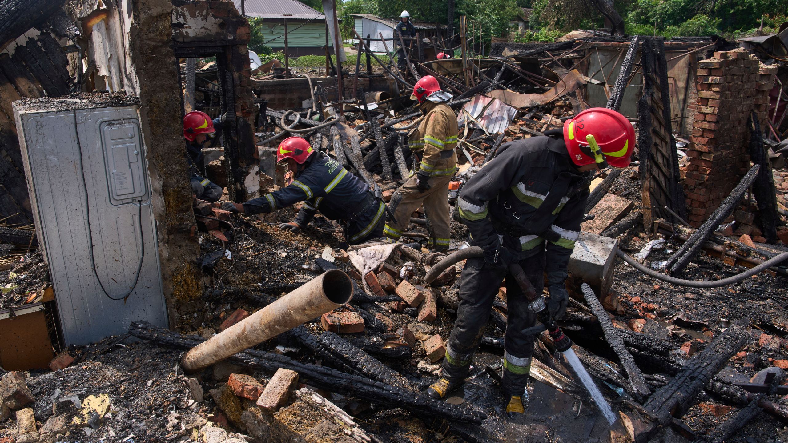 Rescue workers extinguish a fire of a house destroyed by a Russian drone strike in Pryluky village, Ukraine, Thursday, June 5, 2025. (AP Photo/Evgeniy Maloletka)