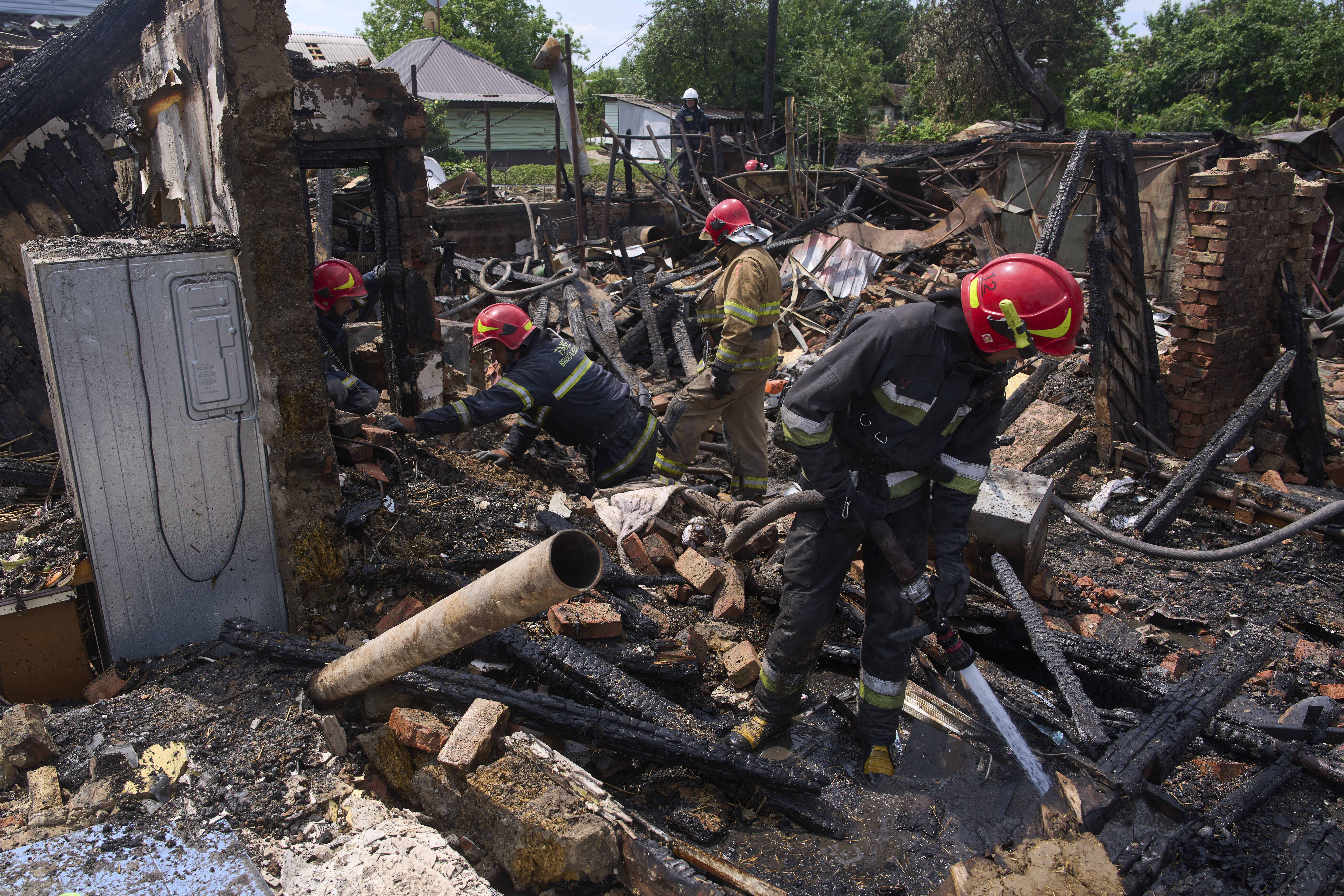 Rescue workers extinguish a fire of a house destroyed by a Russian drone strike in Pryluky village, Ukraine, Thursday, June 5, 2025. (AP Photo/Evgeniy Maloletka)