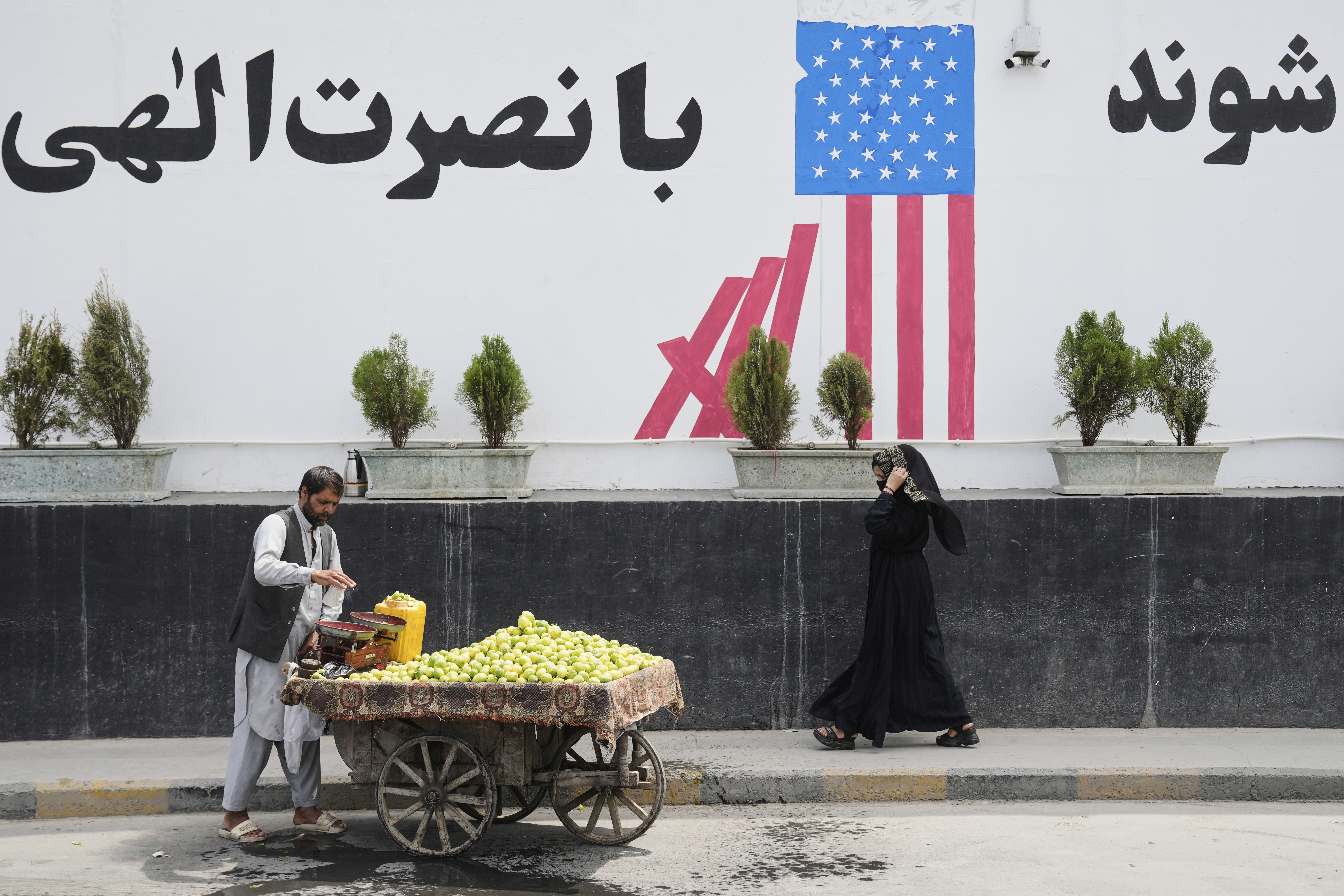 A vendor waits for customers in front of the former US embassy in Kabul, Afghanistan, Thursday, June 5, 2025. (AP Photo/Ebrahim Noroozi)