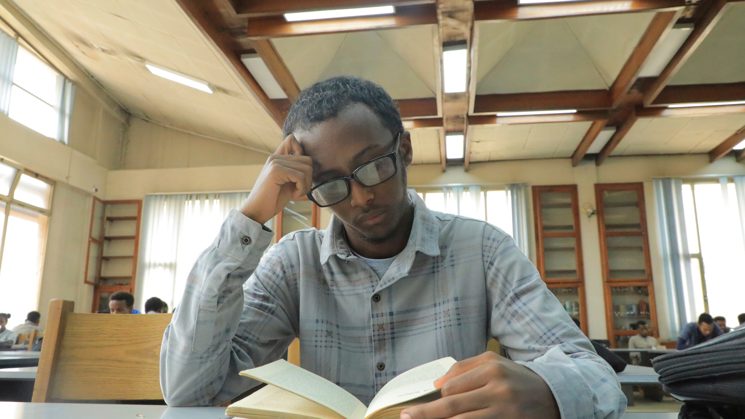 Yonas Nuguse, 21 years old, reads a book at Wemezeker National Library in Addis Ababa, Ethiopia Friday, May 30, 2025. (AP Photo/Amanuel Birhane)