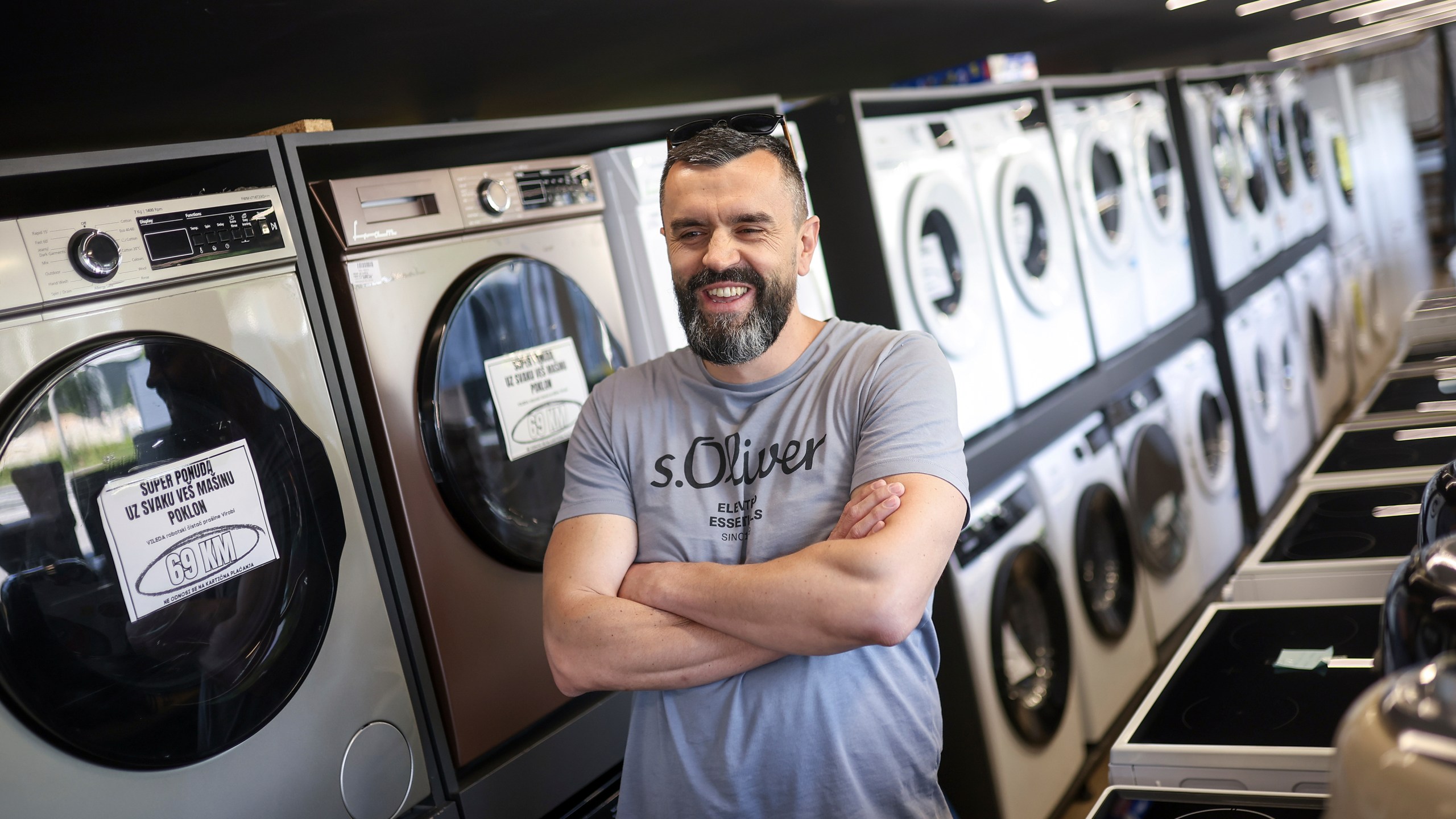 Mirnes Fatic, one of the owners of "Only fools and horses ltd." home appliance store, smiles during an interview for the Associated Press in Hadzici, suburb of Sarajevo, Bosnia, Wednesday, June 4, 2025. (AP Photo/Armin Durgut)