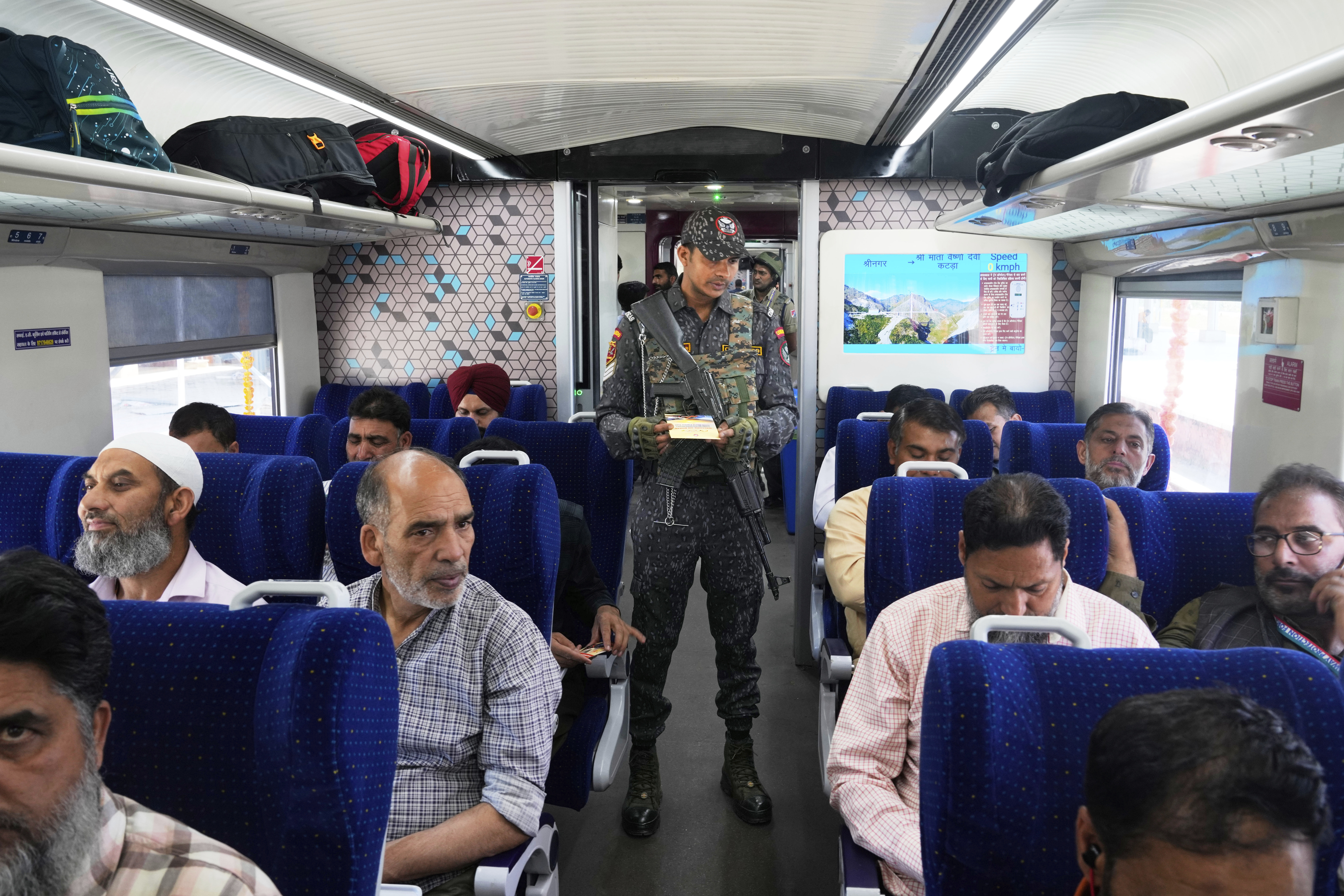 An armed commando inspects tickets inside Vande Bharat Express train soon to be inaugurated to run between Srinagar and Katra, in Srinagar, Indian controlled Kashmir, Friday, June 6, 2025. (AP Photo/Dar Yasin)
