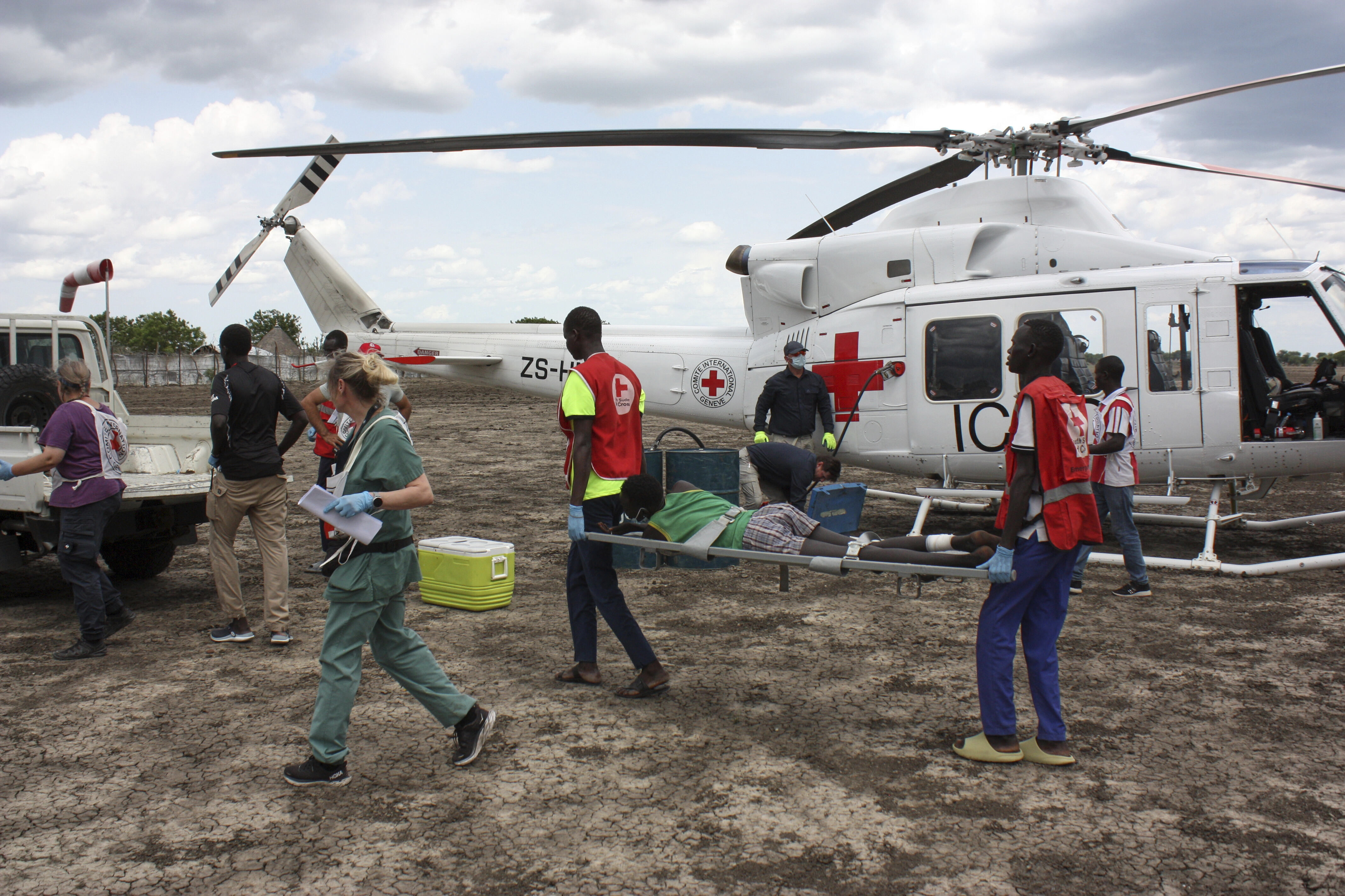 FILE - Medical staff with the International Committee of the Red Cross (ICRC) and South Sudan Red Cross, move a wounded patient to an ambulance in Akobo, South Sudan, Saturday, May 24, 2025. (AP Photo/Joseph Falzetta, file)