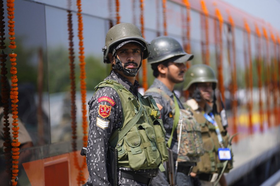 Security personnel stand guard next to Vande Bharat Express train which is soon to be inaugurated to run between Srinagar and Katra, in Srinagar, Indian controlled Kashmir, Friday, June 6, 2025. (AP Photo/Dar Yasin)