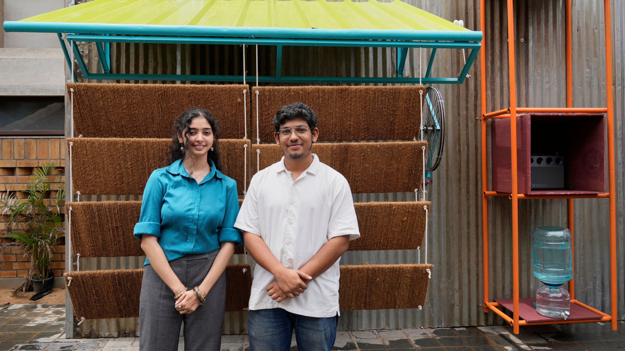 Ankritya Diggavi, left, and Sagar Kandal, architects behind the design of Neralu, an innovative portable heat shelter, pose in front of their installation at the Sweat and Concrete 2025 event in Bengaluru, India, Thursday, May 29, 2025. (AP Photo/Aijaz Rahi)