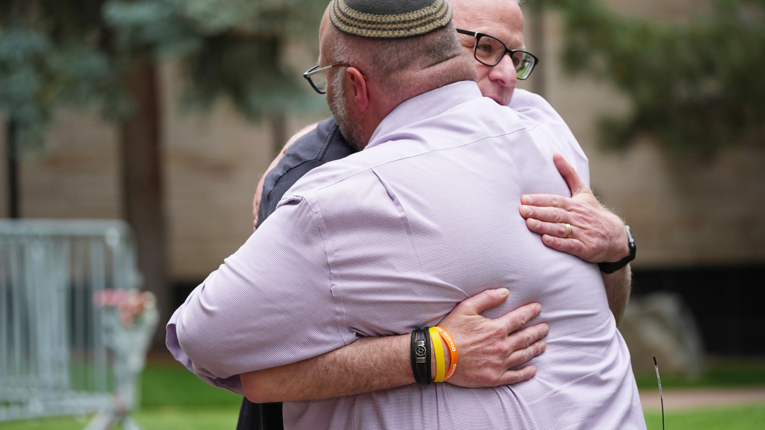 Rabbi Fred Greene of Congregation Har Hashem, front, hugs a man outside of the Boulder County, Colo., courthouse after Sunday's attack, Monday, June 2, 2025, in Boulder, Colo. (AP Photo/David Zalubowski)