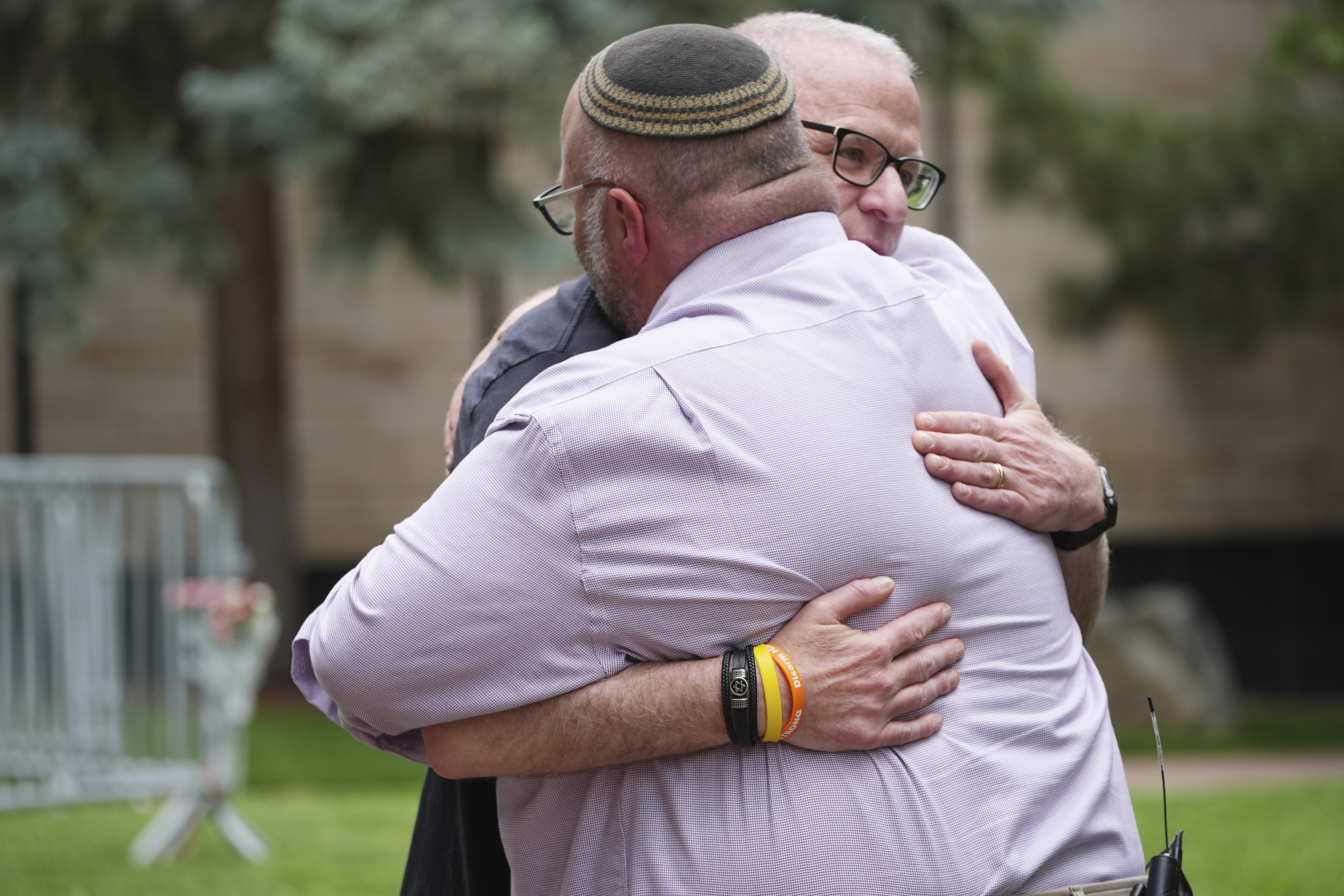 Rabbi Fred Greene of Congregation Har Hashem, front, hugs a man outside of the Boulder County, Colo., courthouse after Sunday's attack, Monday, June 2, 2025, in Boulder, Colo. (AP Photo/David Zalubowski)
