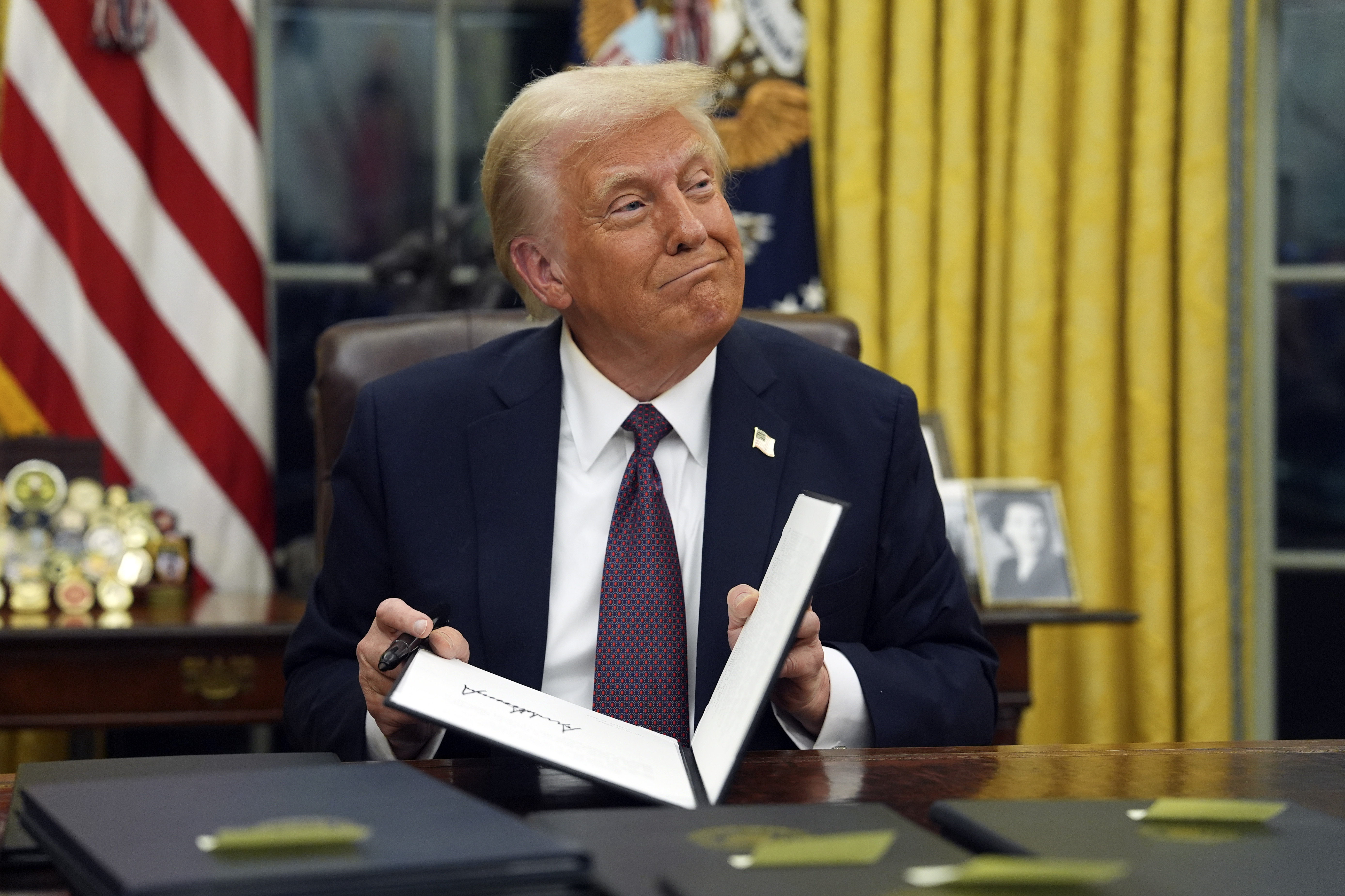 FILE - President Donald Trump signs executive orders in the Oval Office of the White House, Jan. 20, 2025, in Washington. (AP Photo/Evan Vucci, File)