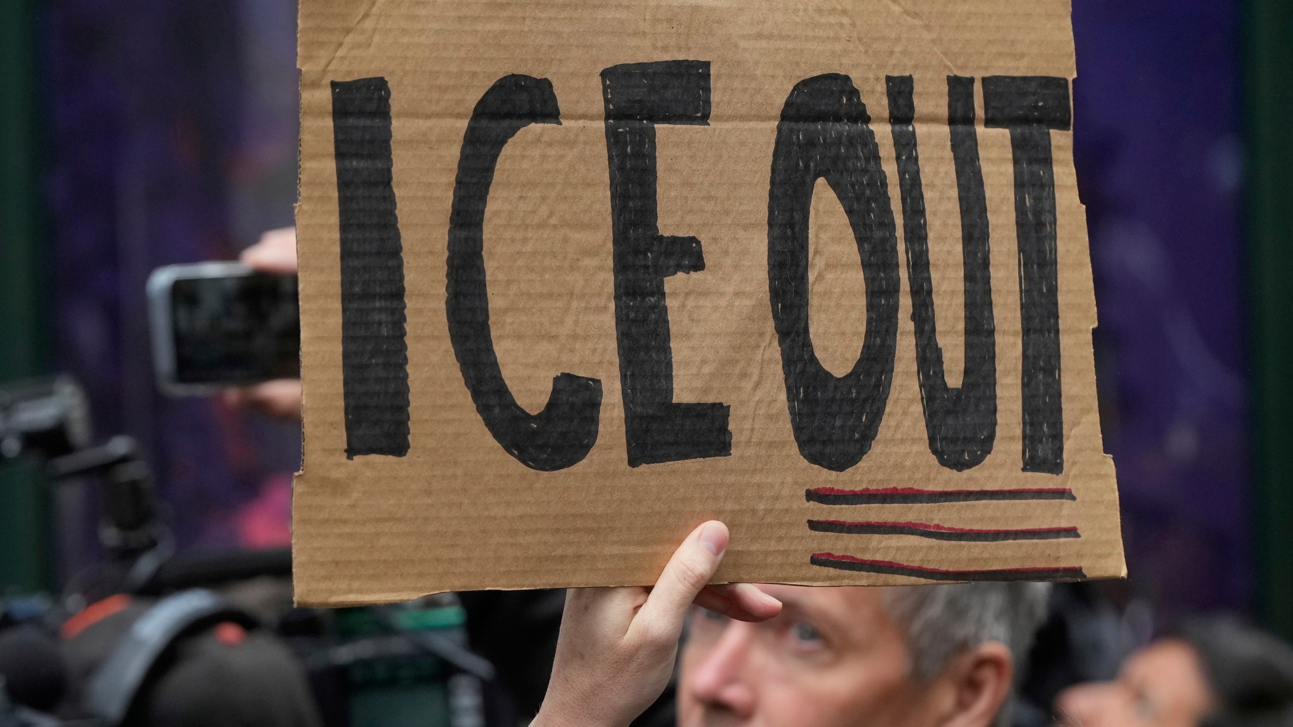 A person holds up a sign during a news conference and rally by immigrant justice organizations and advocates protesting ICE arrests in San Francisco, Wednesday, May 28, 2025. (AP Photo/Jeff Chiu)