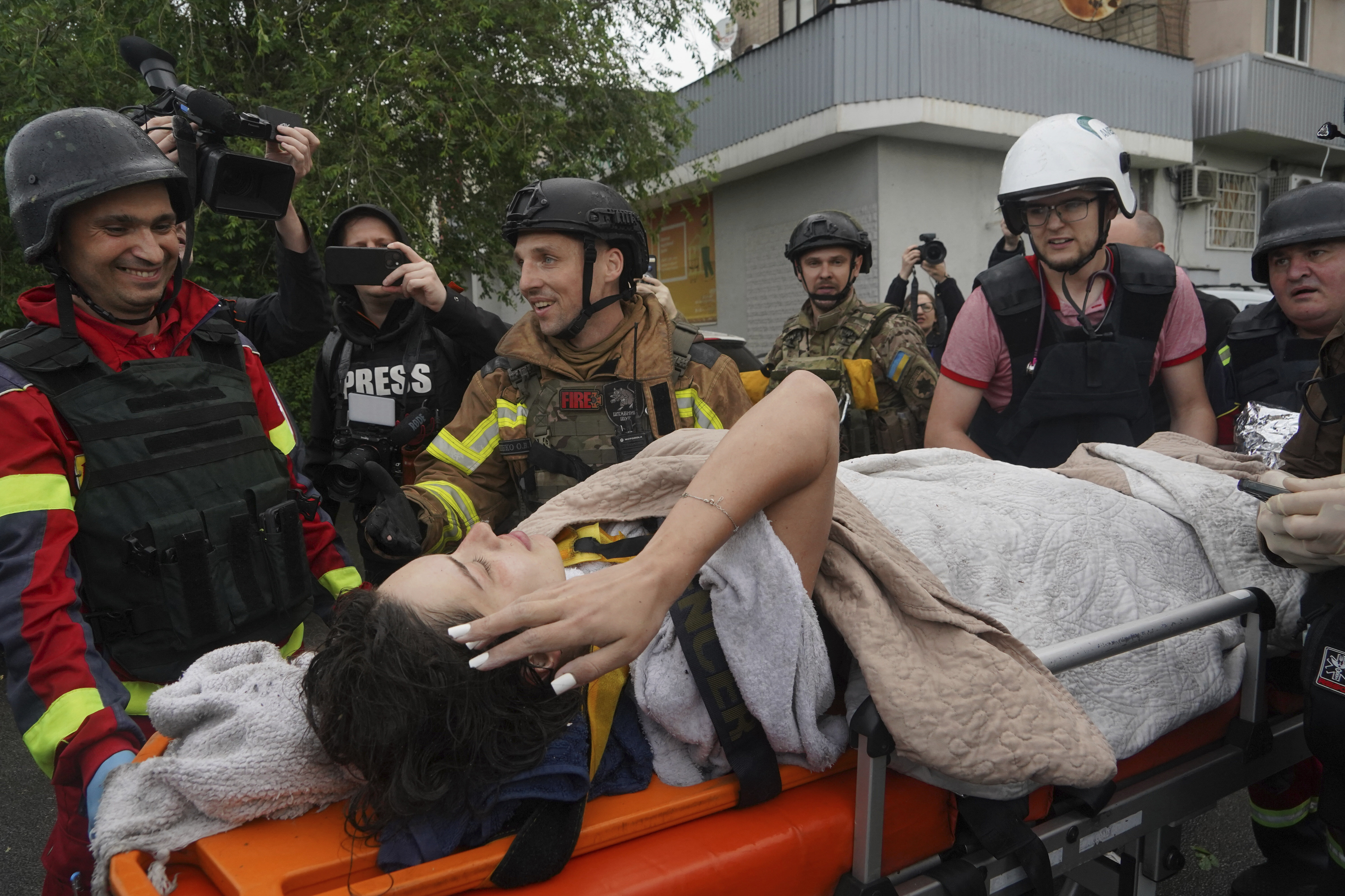 Rescuers carry a wounded woman after Russian attack that hit a residential building in Kharkiv, Ukraine, Saturday, June 7, 2025. (AP Photo/Andrii Marienko)