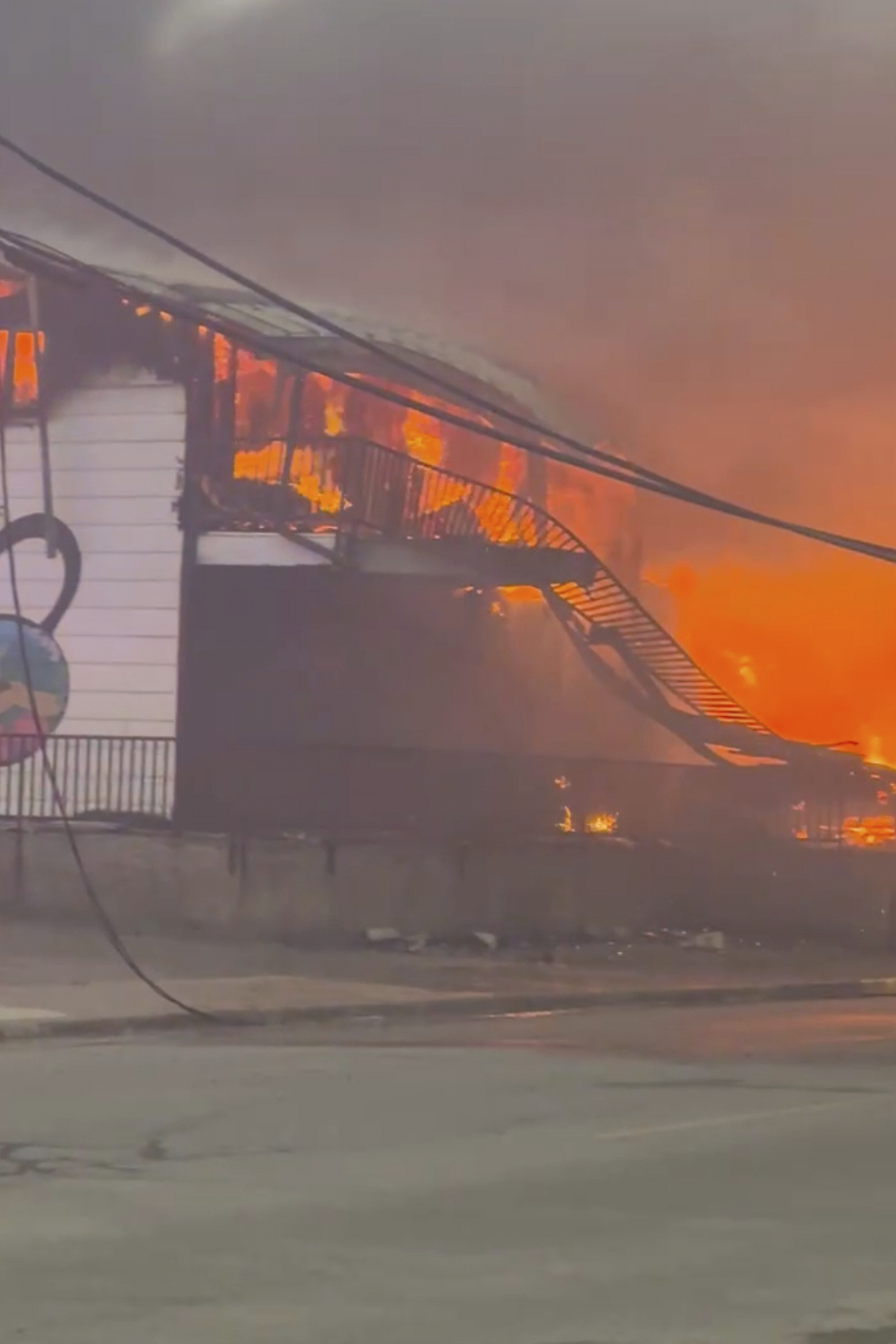In this photo provided by Evan Bell firefighters combat the wildfires as they consumed Robertson Trading, a general store, in La Ronge, Saskatchewan on June 3, 2025. (Evan Bell via AP)