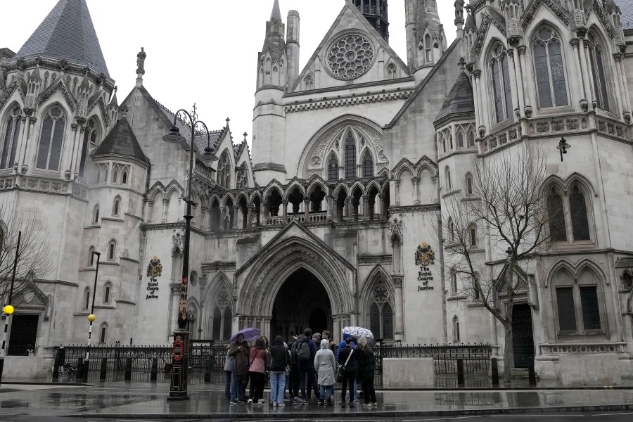 FILE - People stand outside the Royal Court of Justice in London, Friday, March 17, 2023. (AP Photo/Frank Augstein, File)