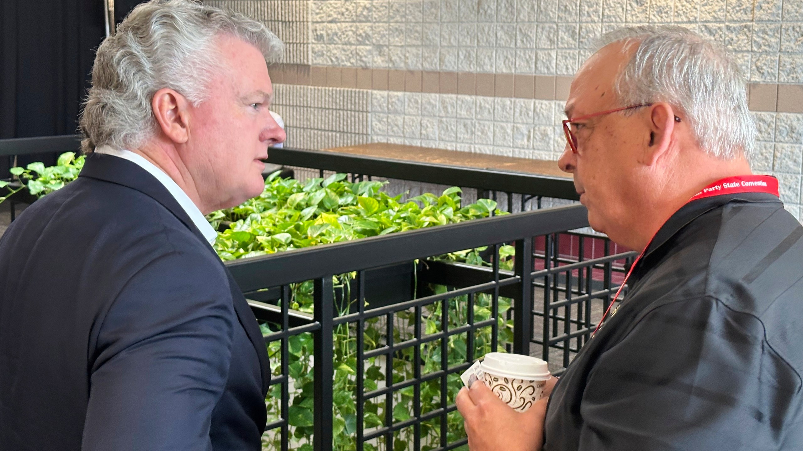 U.S. Rep. Mike Collins, left, R-Ga., speaks to an attendee at the Georgia Republican Convention in Dalton, Ga., Saturday, June 7, 2025. (AP Photo/Jeff Amy)