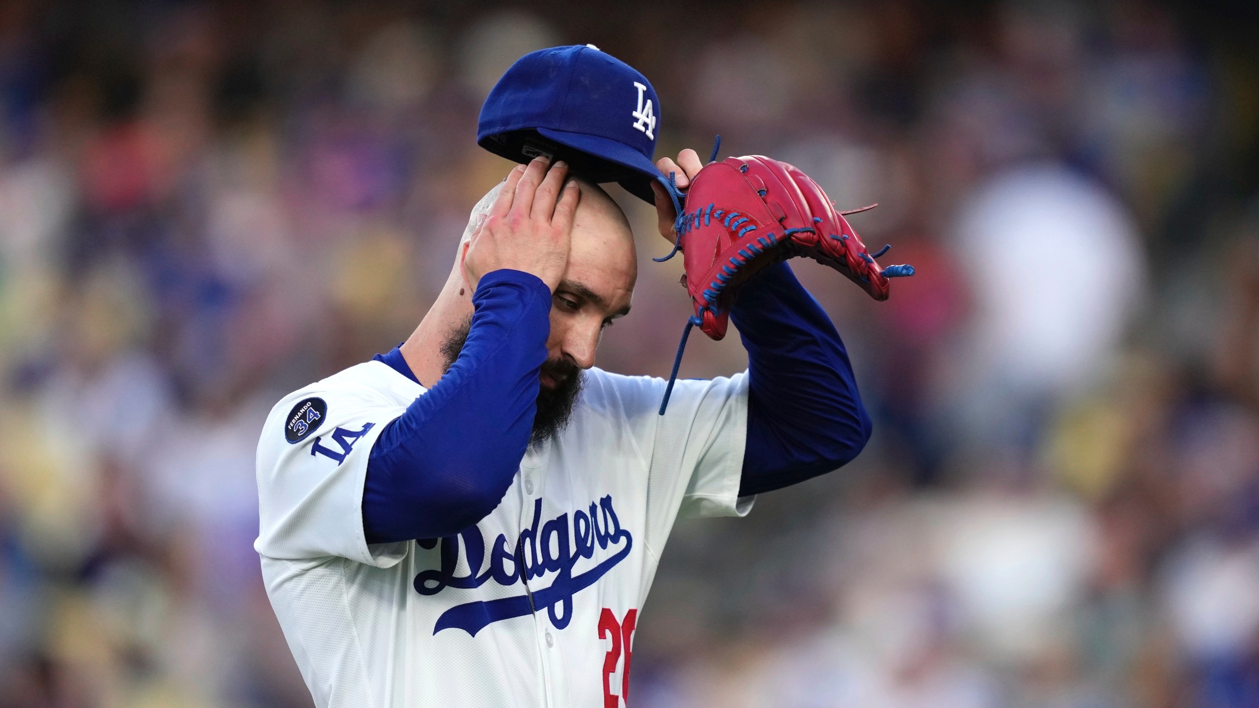 Los Angeles Dodgers starting pitcher Tony Gonsolin wipes his head as he walks off the fields after the top of the first inning of a baseball game against the New York Mets, Wednesday, June 4, 2025, in Los Angeles. (AP Photo/Mark J. Terrill)