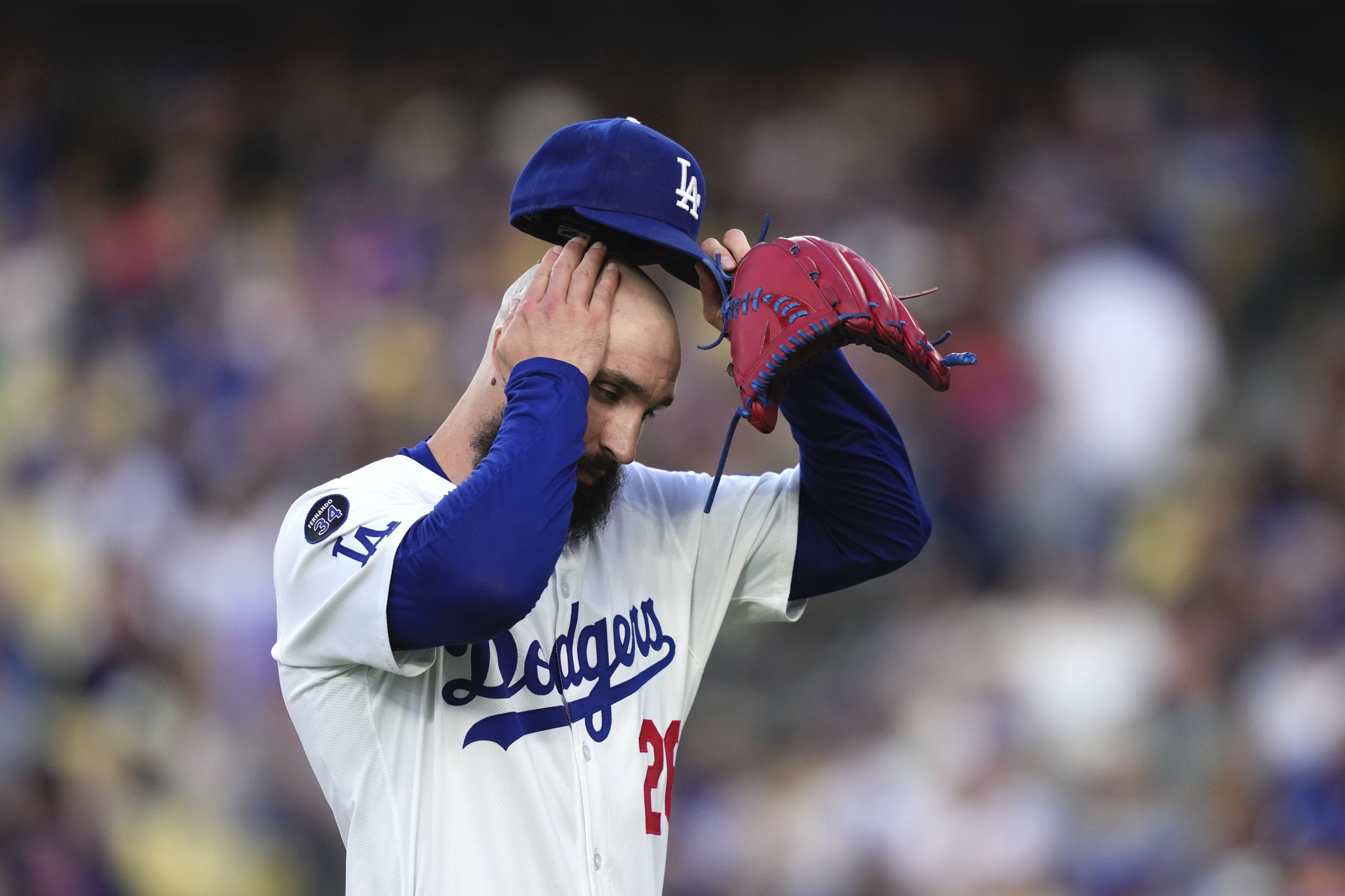 Los Angeles Dodgers starting pitcher Tony Gonsolin wipes his head as he walks off the fields after the top of the first inning of a baseball game against the New York Mets, Wednesday, June 4, 2025, in Los Angeles. (AP Photo/Mark J. Terrill)