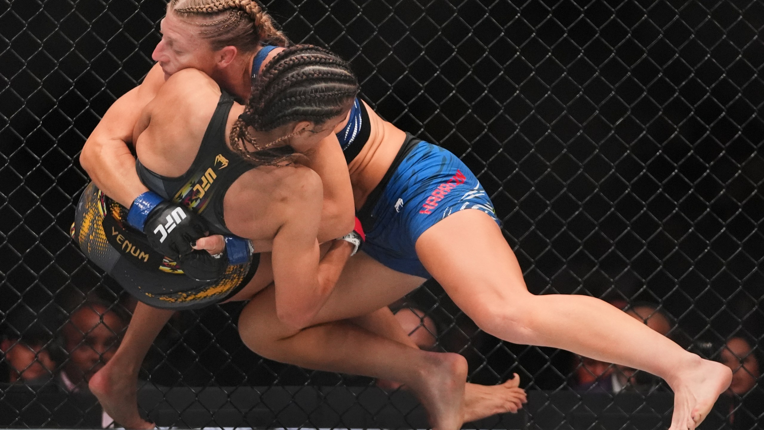 Kayla Harrison, right, grapples with with Julianna Peña during the first round of a women's bantamweight bout at the UFC 316 mixed martial arts event Sunday, June 8, 2025 in Newark, N.J. (AP Photo/Frank Franklin II)