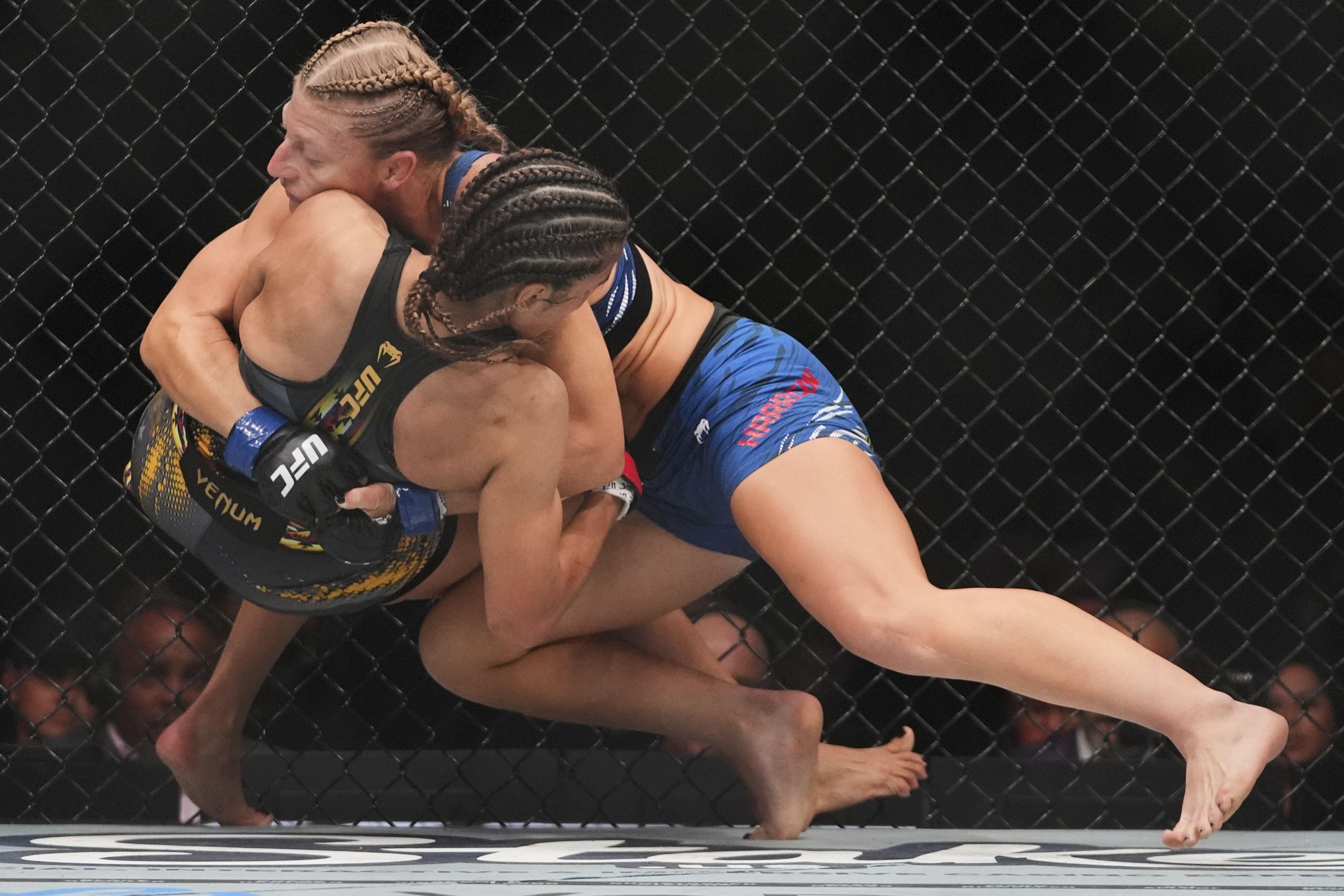 Kayla Harrison, right, grapples with with Julianna Peña during the first round of a women's bantamweight bout at the UFC 316 mixed martial arts event Sunday, June 8, 2025 in Newark, N.J. (AP Photo/Frank Franklin II)