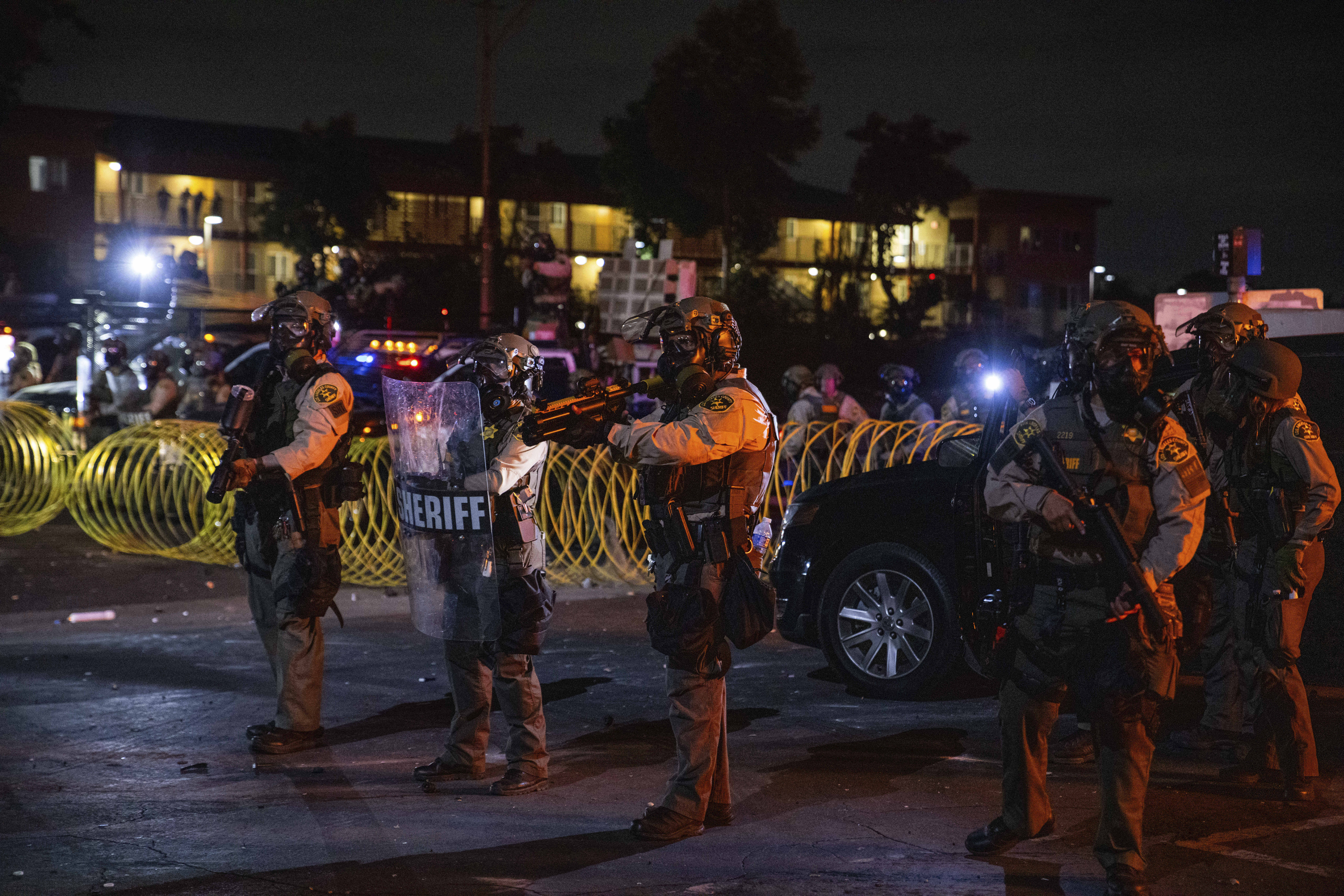Los Angeles County Sheriffs stand during a protest in Compton, Calif., Saturday, June 7, 2025, after federal immigration authorities conducted operations. (AP Photo/Ethan Swope)