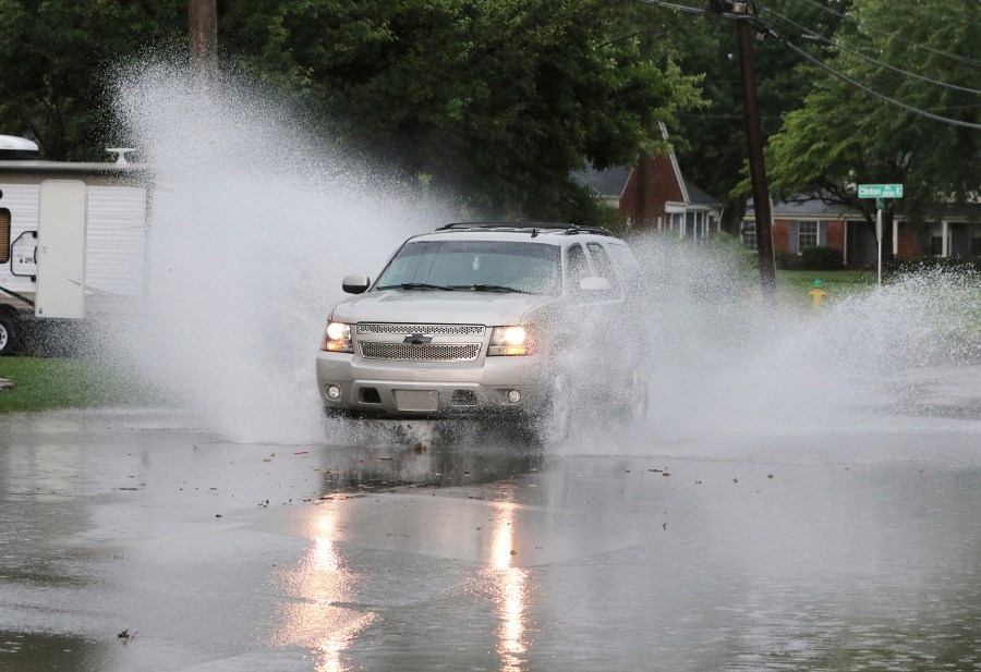 A motorist drives through some standing water along the 2100 block of Ford Avenue during the storm that hit on Friday afternoon in Owensboro, Ky. on June 6, 2025. (Alan Warren/The Messenger-Inquirer via AP)