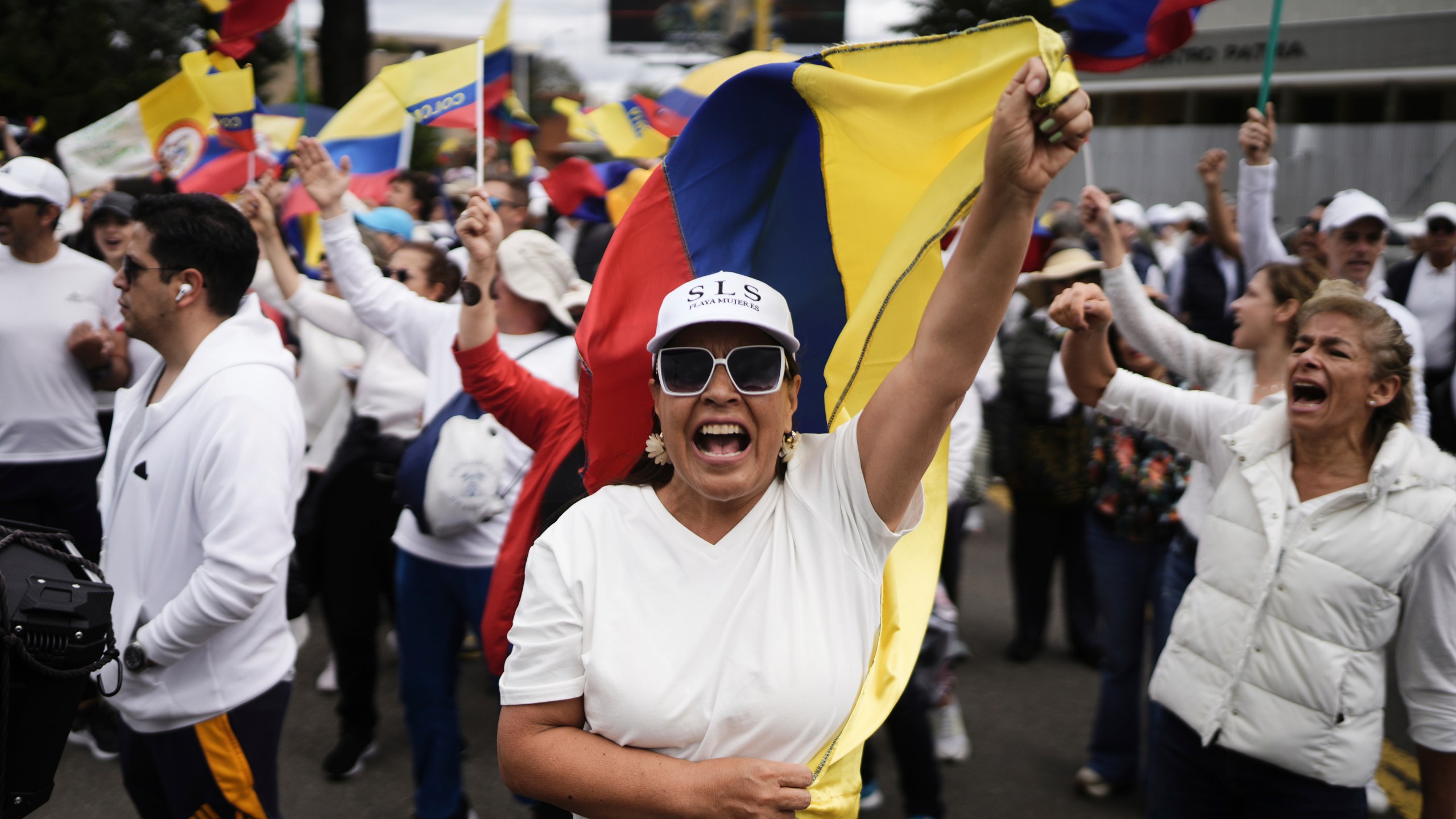 People march to the clinic where Colombian Senator Miguel Uribe Turbay is being treated after he was shot, in Bogota, Colombia, Sunday, June 8, 2025. (AP Photo/Ivan Valencia)