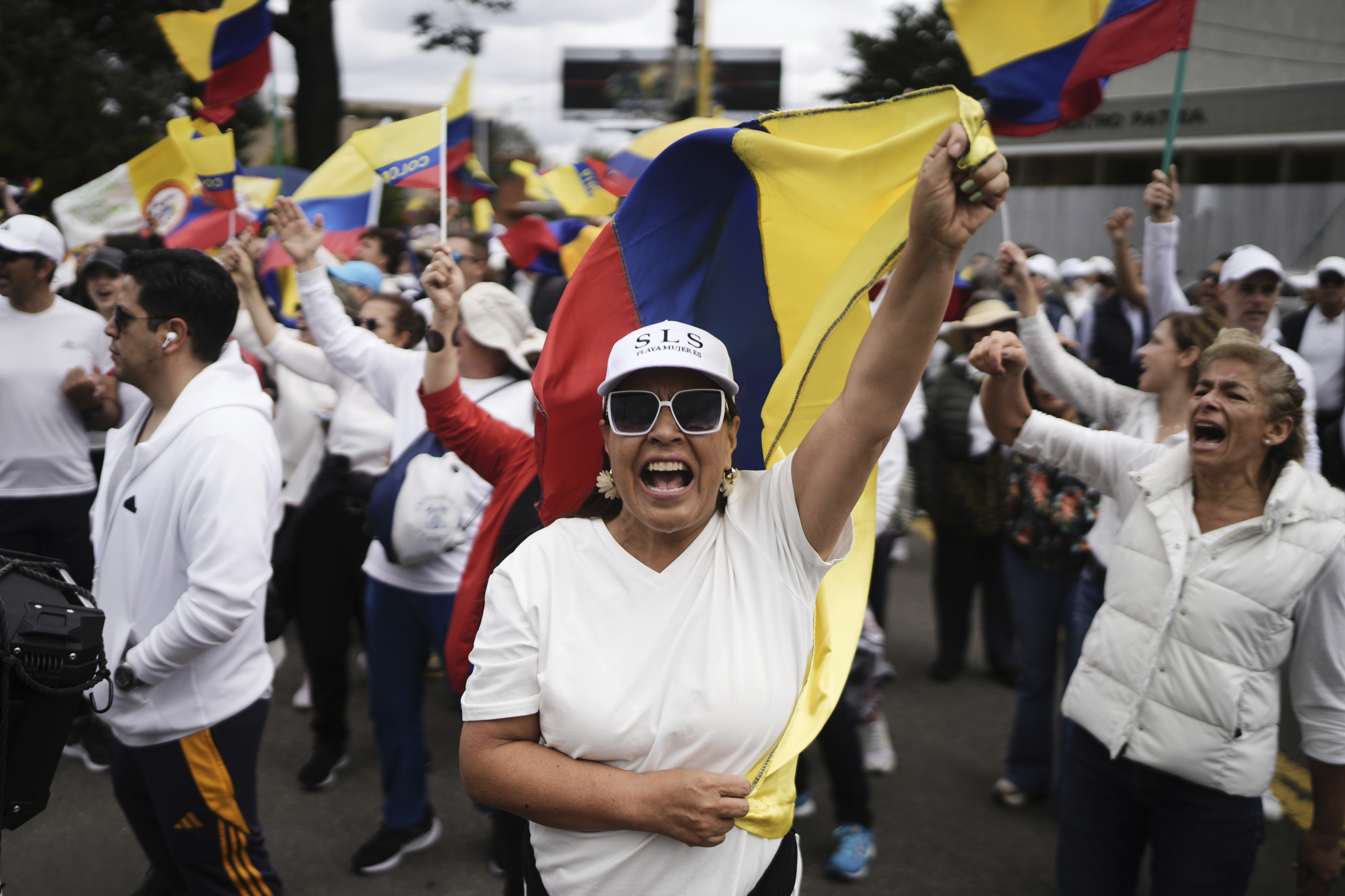 People march to the clinic where Colombian Senator Miguel Uribe Turbay is being treated after he was shot, in Bogota, Colombia, Sunday, June 8, 2025. (AP Photo/Ivan Valencia)