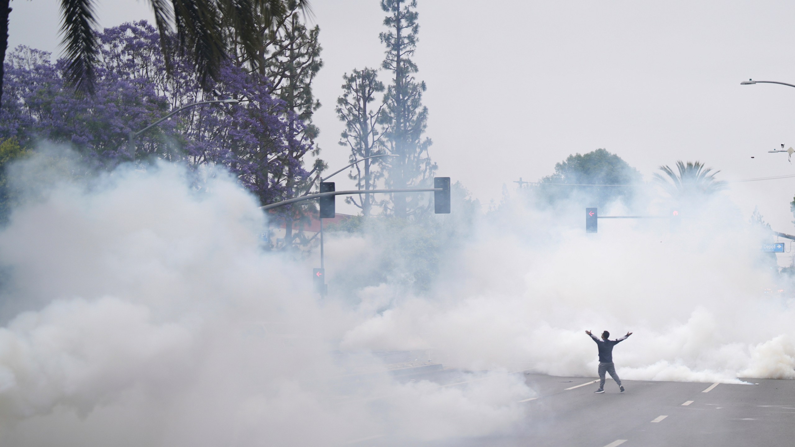 Tear gas fills the street as protesters confront Border Patrol personnel during a demonstration over the dozens detained in an operation by federal immigration authorities a day earlier, in Paramount, Calif., on Saturday, June 7, 2025. (AP Photo/Eric Thayer)