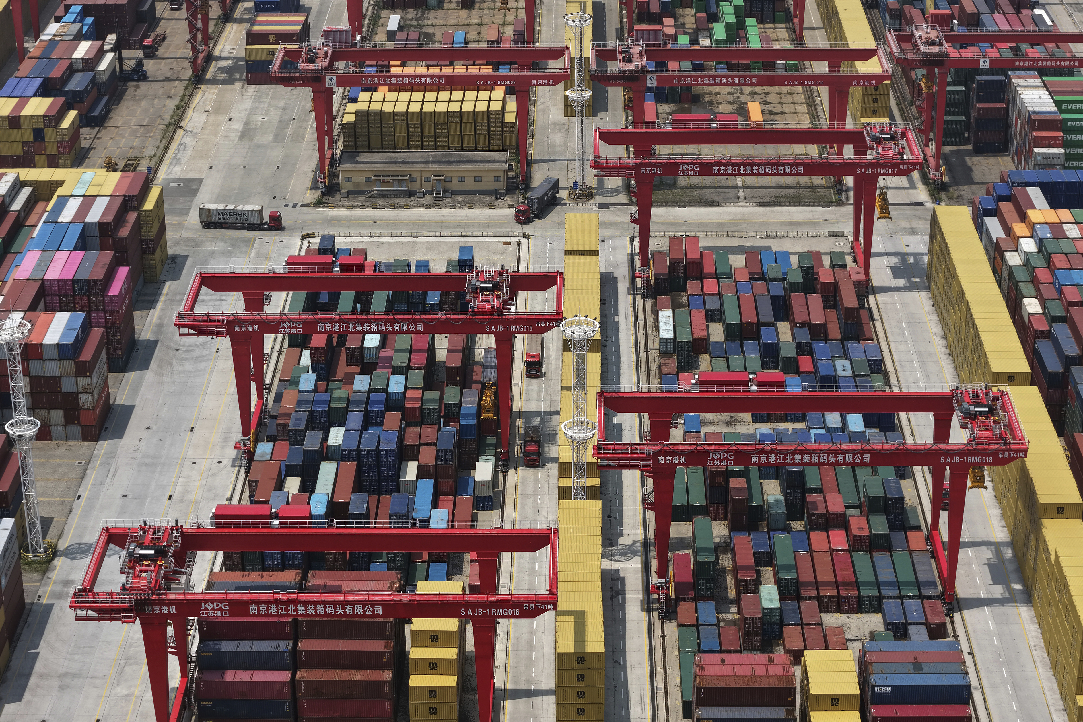 Trucks move through containers piled up at a container terminal in Nanjing in east China's Jiangsu province on June 3, 2025. (Chinatopix Via AP)