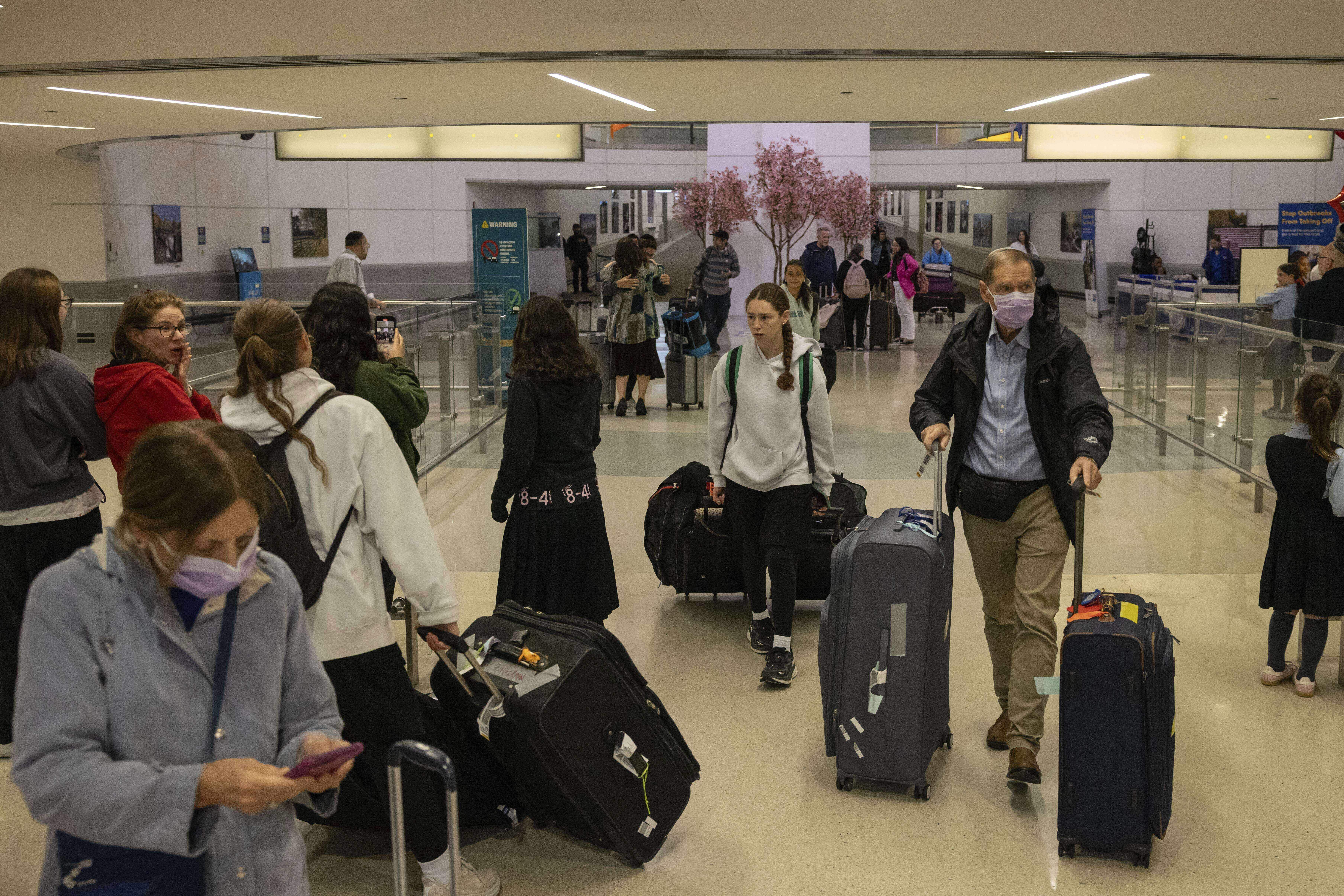 People carrying suitcases arrive from international flight at Newark Liberty International Airport, Monday, June 9, 2025, in New Jersey. (AP Photo/Yuki Iwamura)