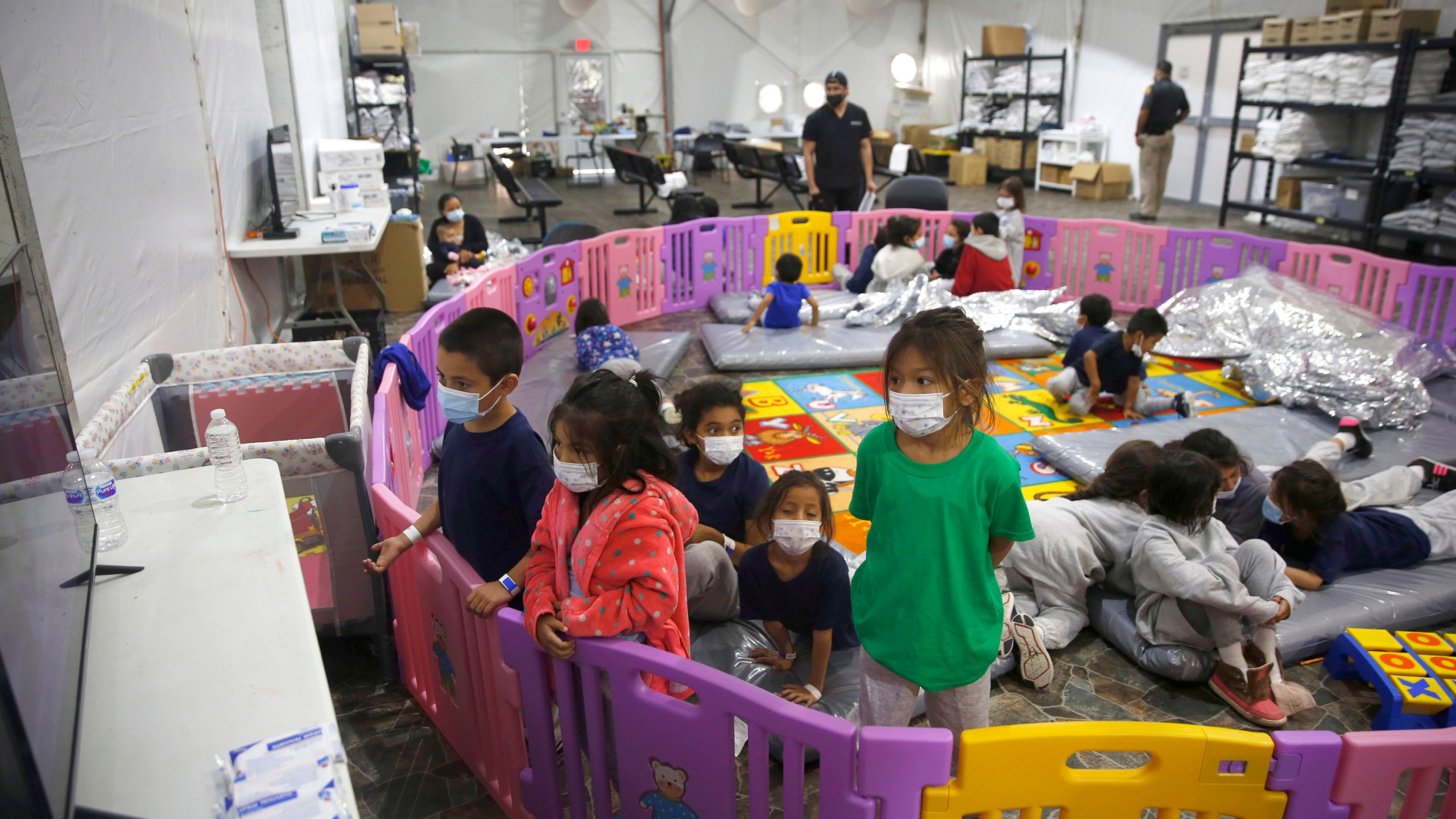 FILE - In this March 30, 2021, file photo, young unaccompanied migrants, watch television inside a playpen at the U.S. Customs and Border Protection facility, the main detention center for unaccompanied children in the Rio Grande Valley, in Donna, Texas. (AP Photo/Dario Lopez-Mills, Pool, File)