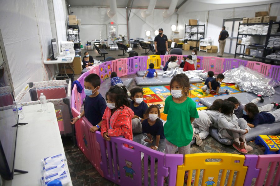 FILE - In this March 30, 2021, file photo, young unaccompanied migrants, watch television inside a playpen at the U.S. Customs and Border Protection facility, the main detention center for unaccompanied children in the Rio Grande Valley, in Donna, Texas. (AP Photo/Dario Lopez-Mills, Pool, File)