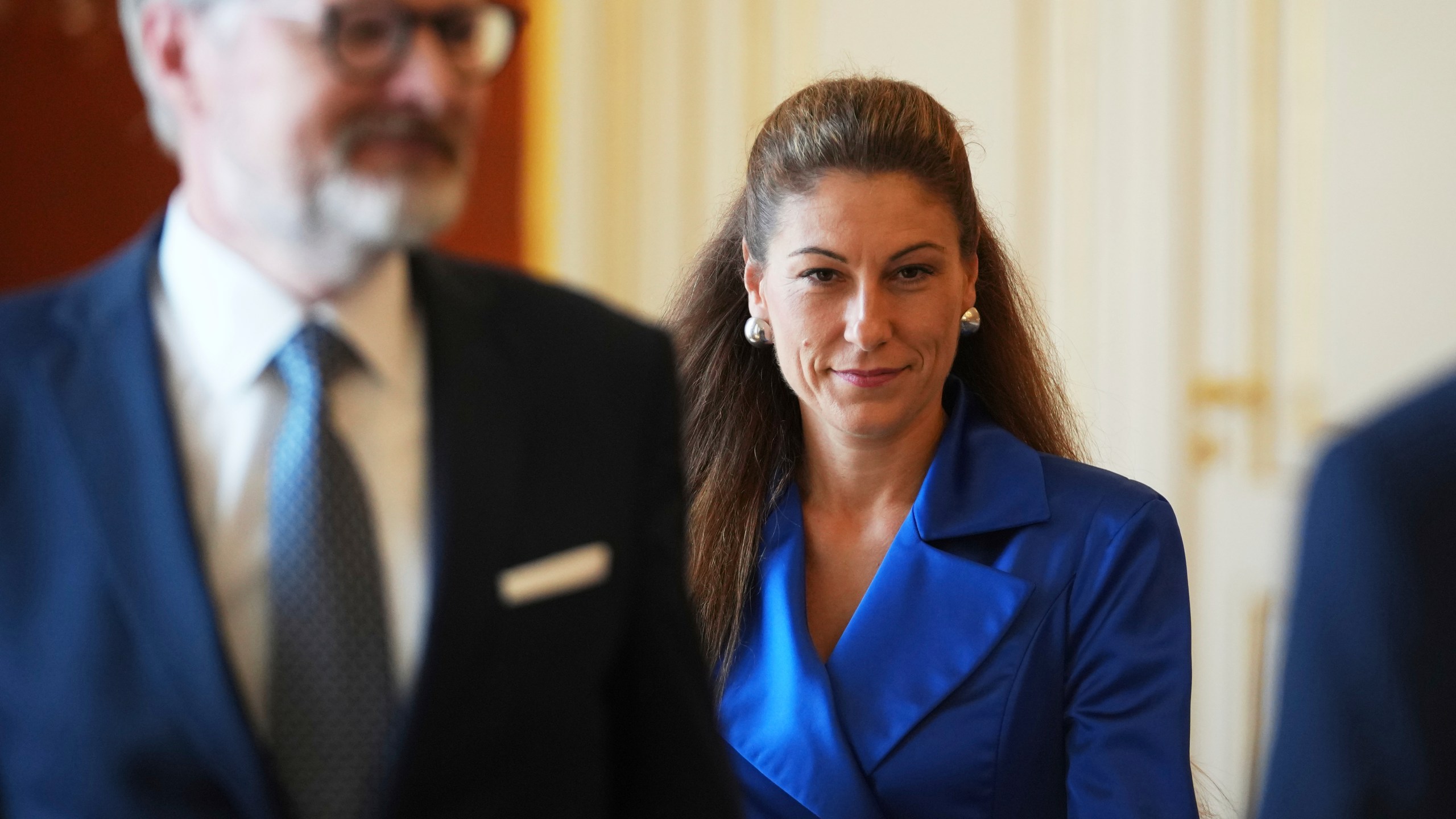 Czech Republic's Prime Minister Petr Fiala, left, looks on as Eva Decroix arrives to be appointed as new Justice Minister at the Prague Castle in Prague, Czech Republic, Tuesday, June 10, 2025. (AP Photo/Petr David Josek)