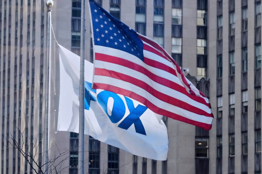 FILE - An American flag and a FOX flag fly outside Fox headquarters, in New York, April 9, 2025. (AP Photo/Richard Drew, File)