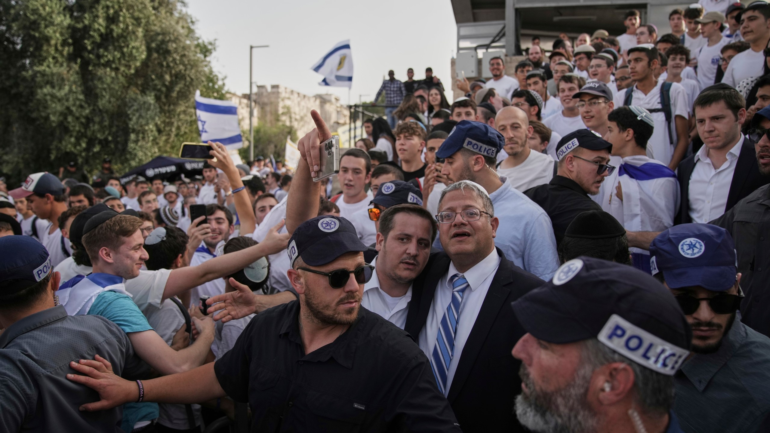 Surrounded by security guards, Israel's far-right National Security Minister, Itamar Ben-Gvir, center, participates in march marking Jerusalem Day, an Israeli holiday celebrating the capture of east Jerusalem in the 1967 Mideast war, in Damascus Gate of Jerusalem's Old City, Monday, May 26, 2025. (AP Photo/Leo Correa)