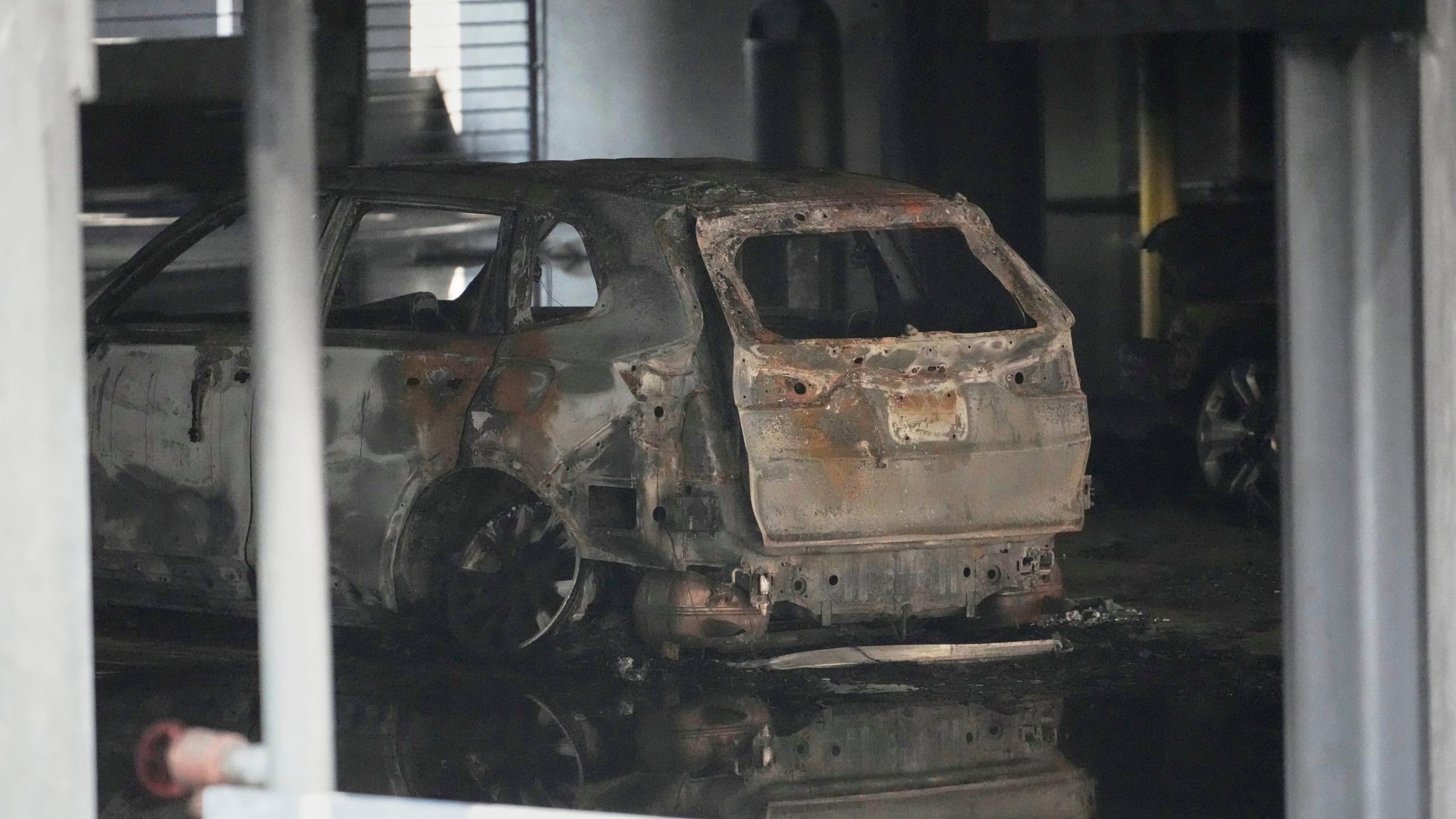 A burned vehicle is seen inside a garage that caught fire and a floor of the structure collapsed Tuesday, June 10, 2025, in Nashville, Tenn. (AP Photo/George Walker IV)