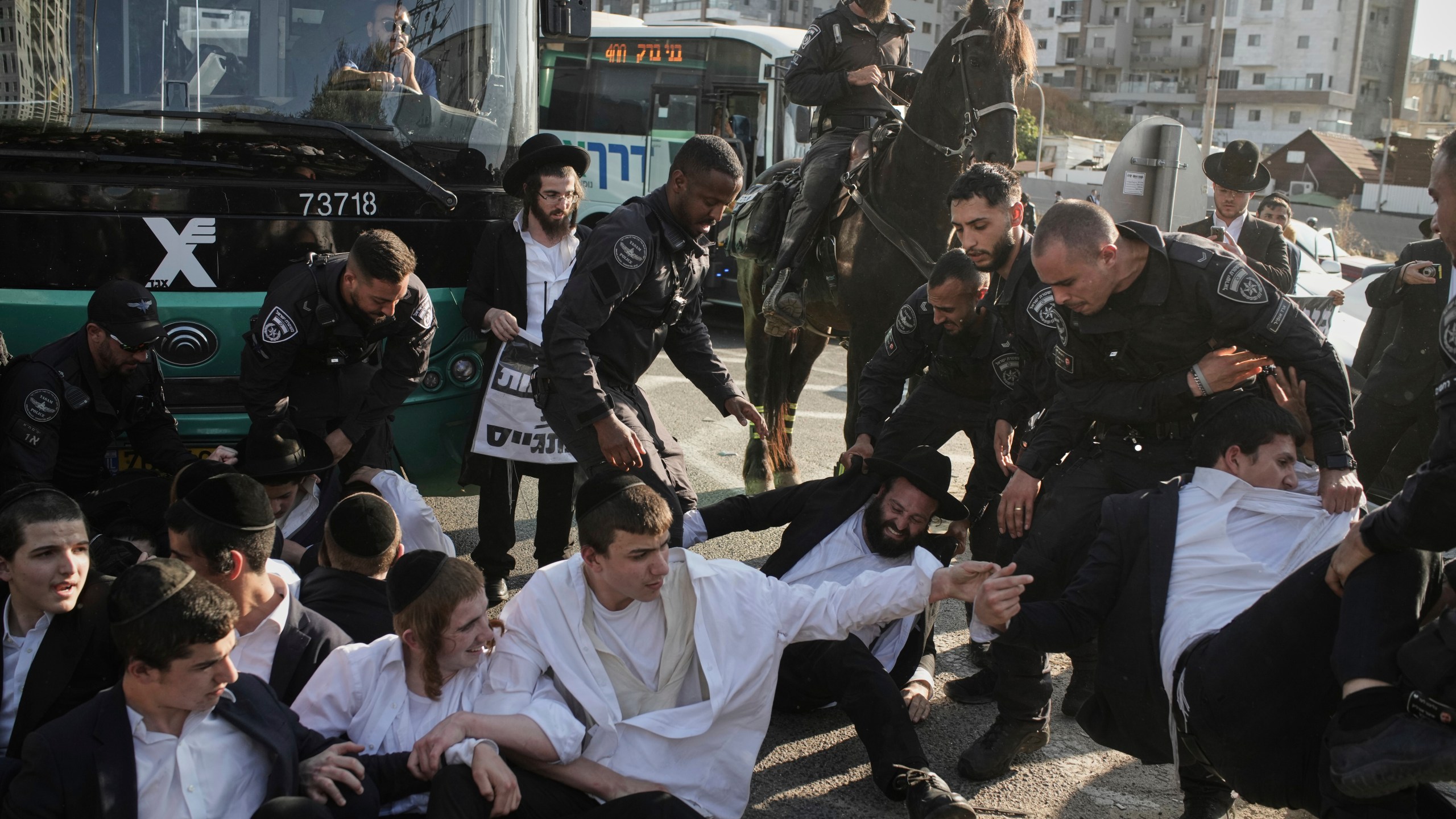 Israeli police officers disperse ultra-Orthodox Jewish men during a protest against army recruitment in Bnei Brak, Israel, Thursday, June 5, 2025. (AP Photo/Leo Correa)